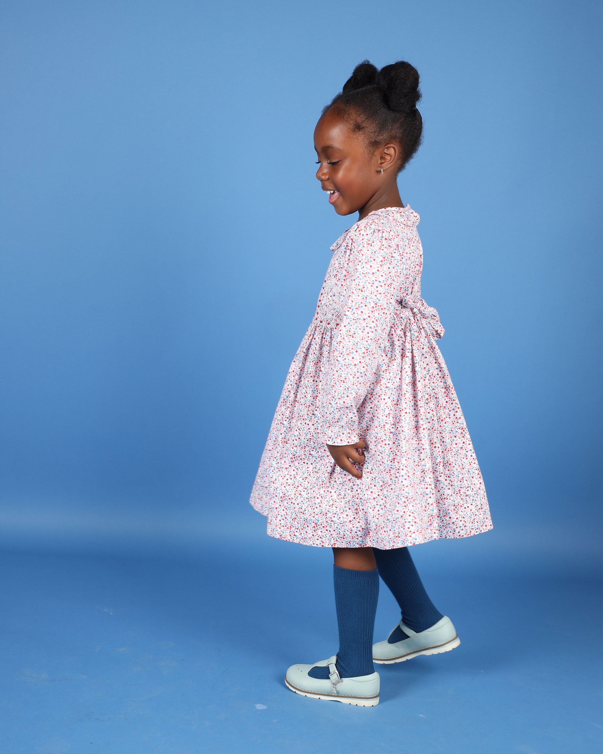 girl in pink and white floral smock dress