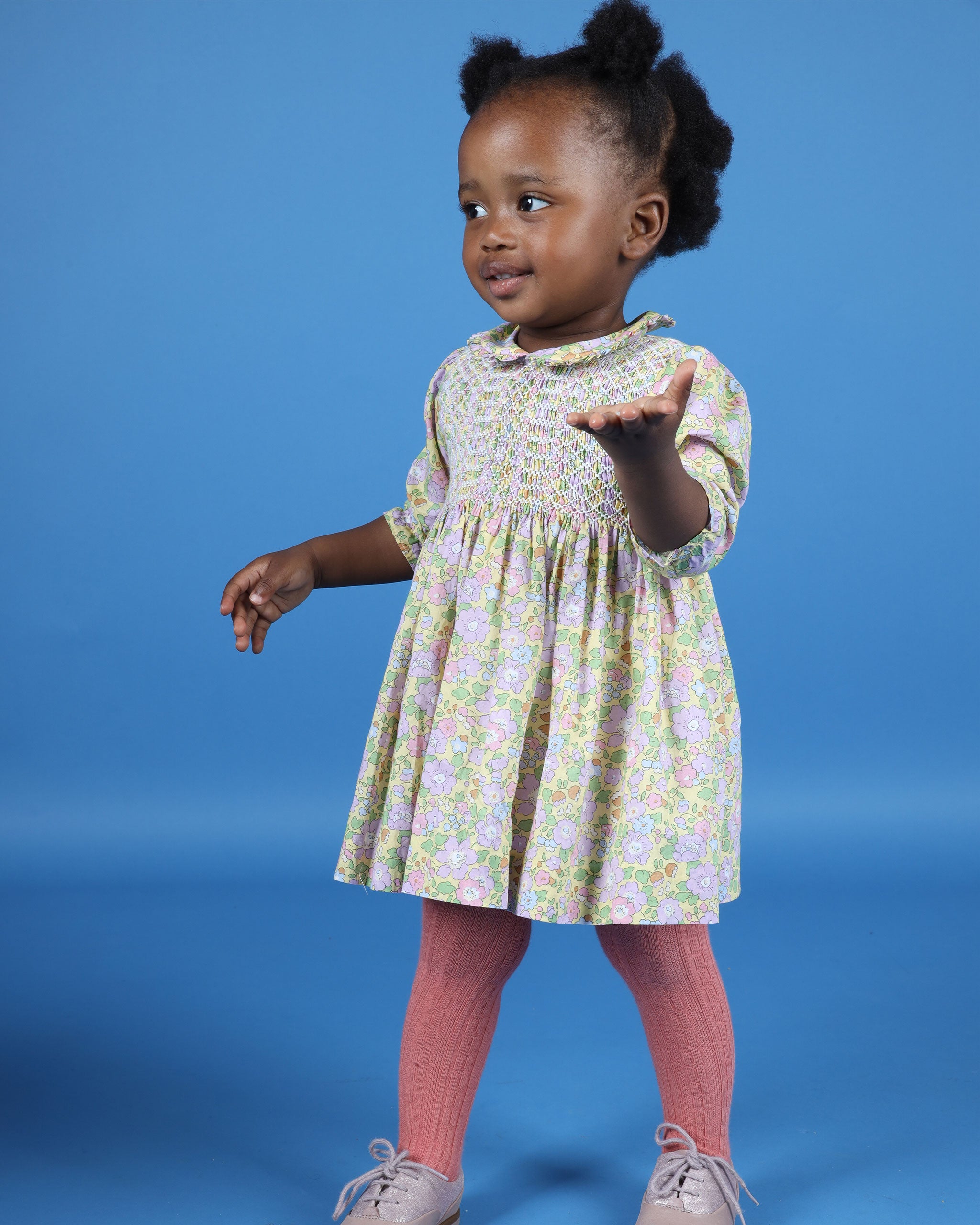 toddler in yellow floral hand-smocked baby dress with bloomers, made from Liberty Fabric