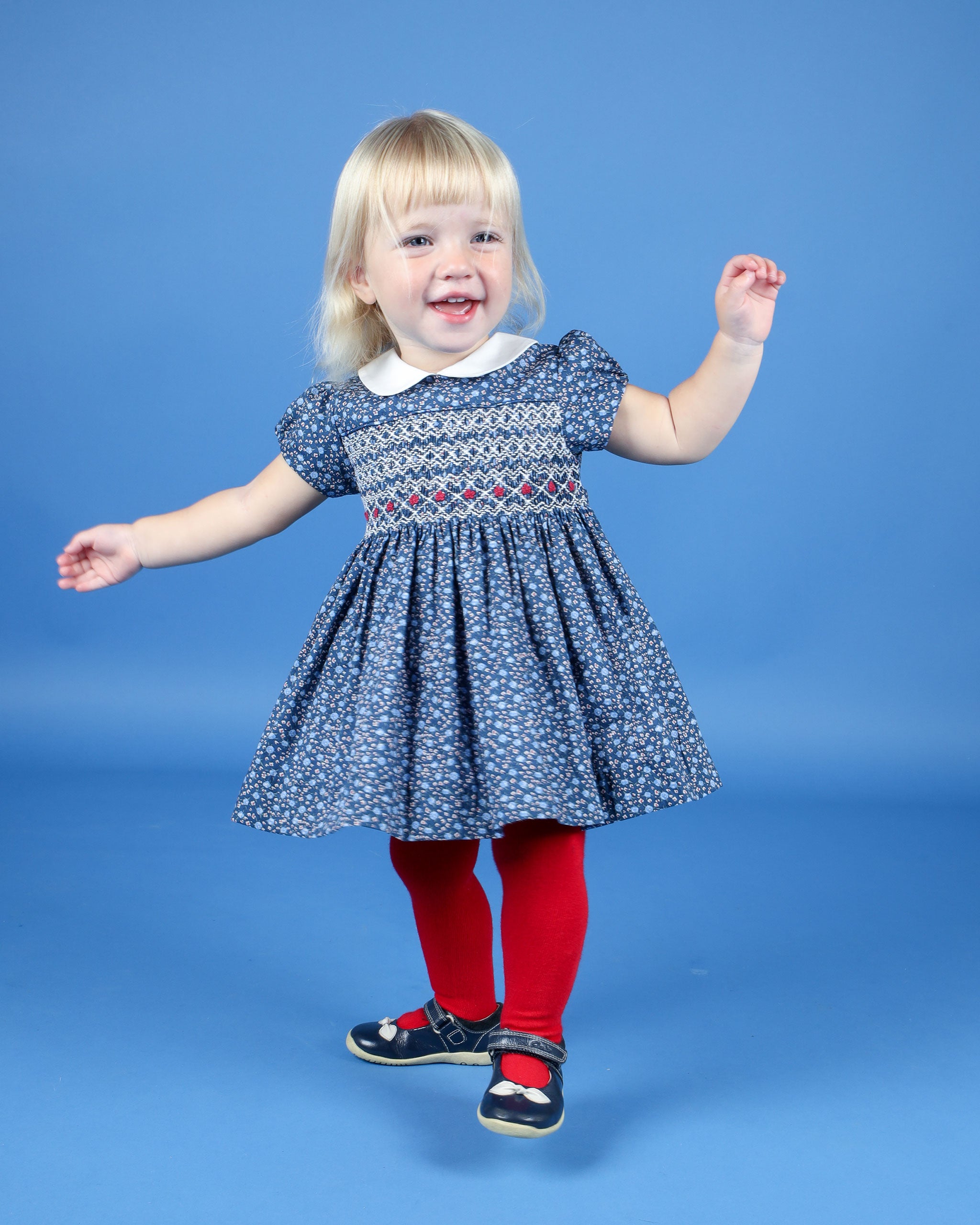 baby in navy smock dress