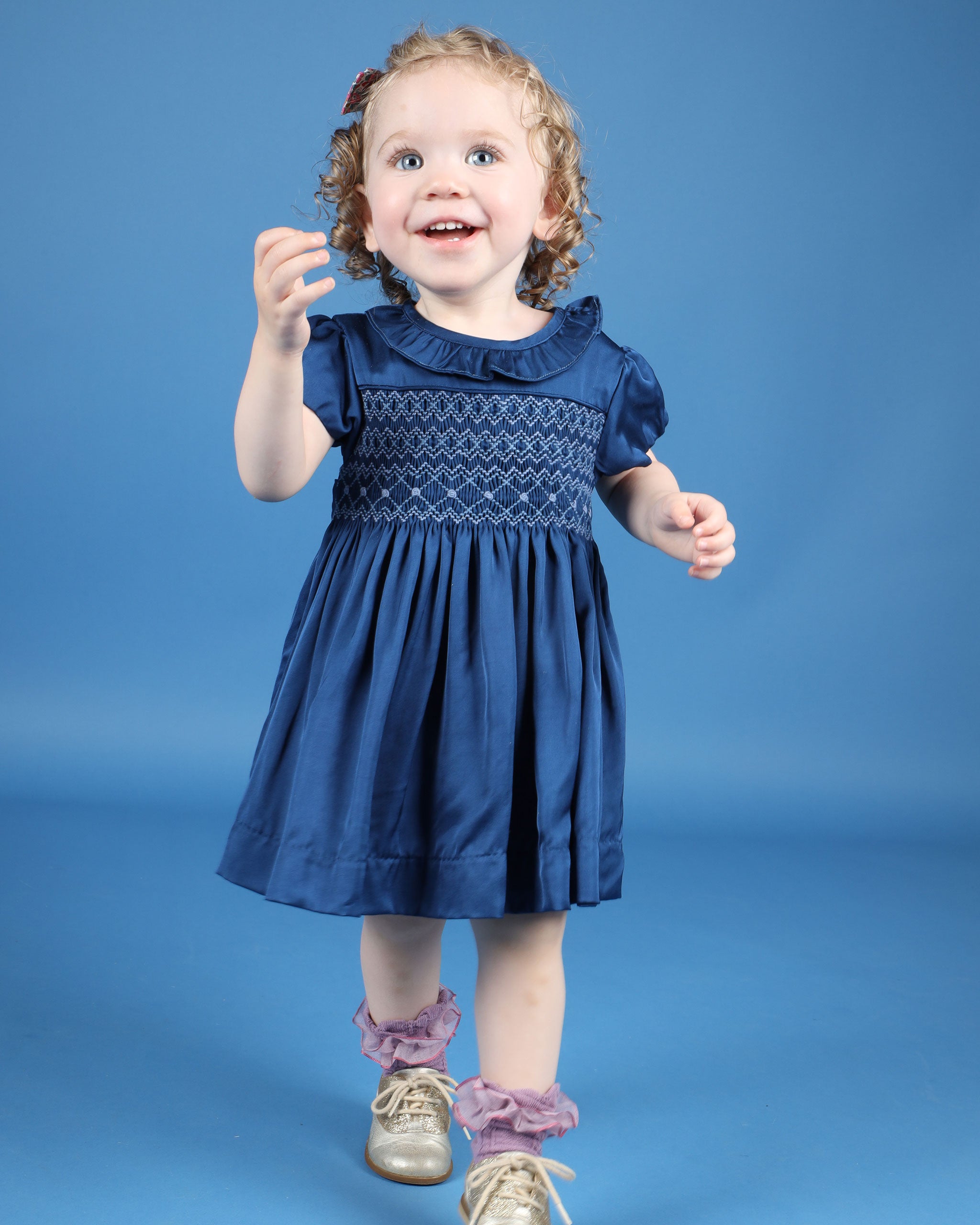 baby in Hand-smocked navy satin party dress with bloomers