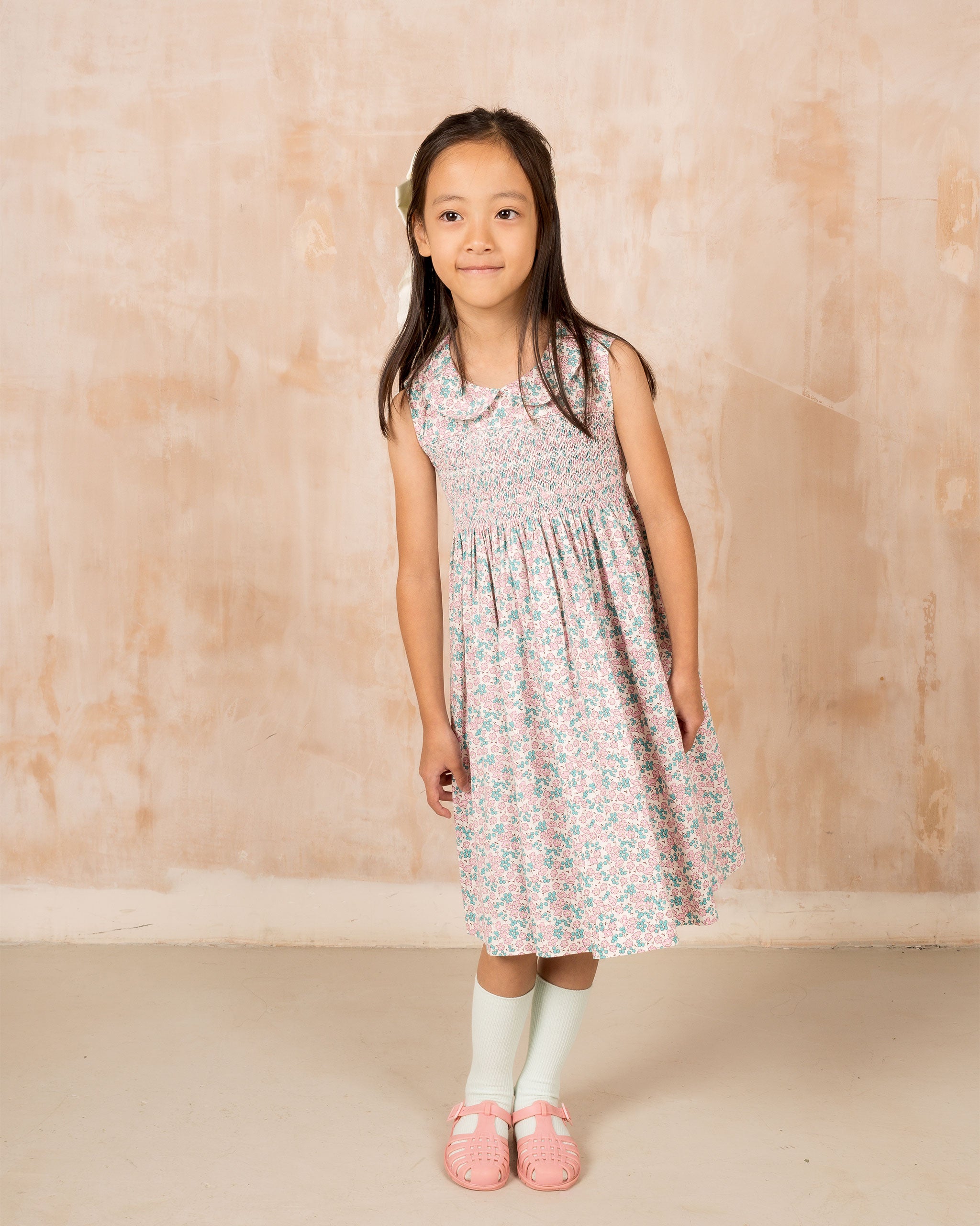 child model in sleeveless smock dress,