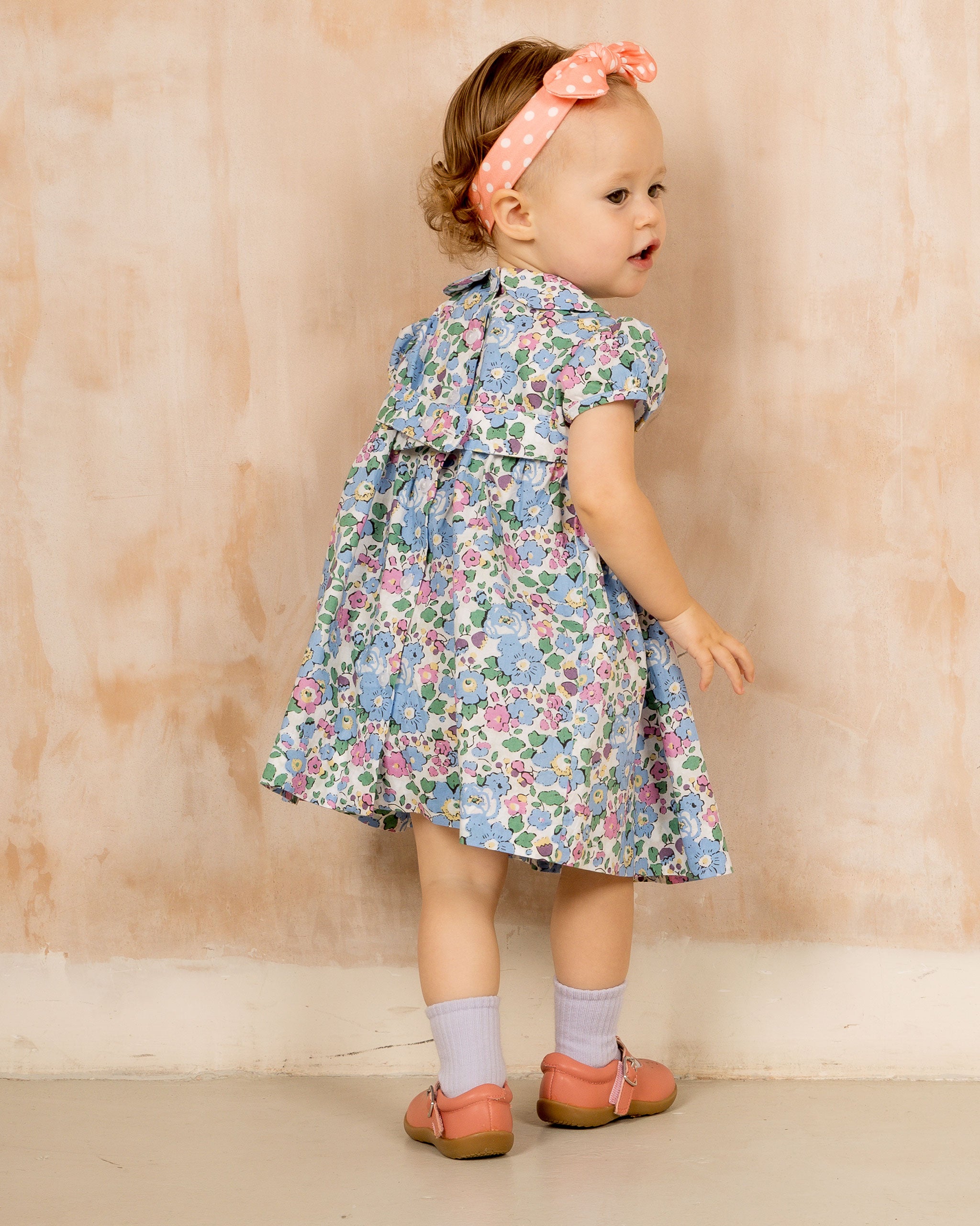 baby model in hand-smocked dress, back view