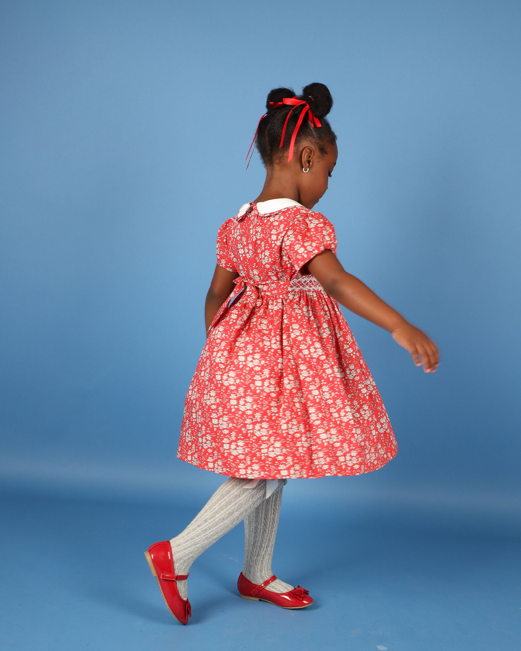 girl in red and white floral dress made form Liberty Fabric, back view