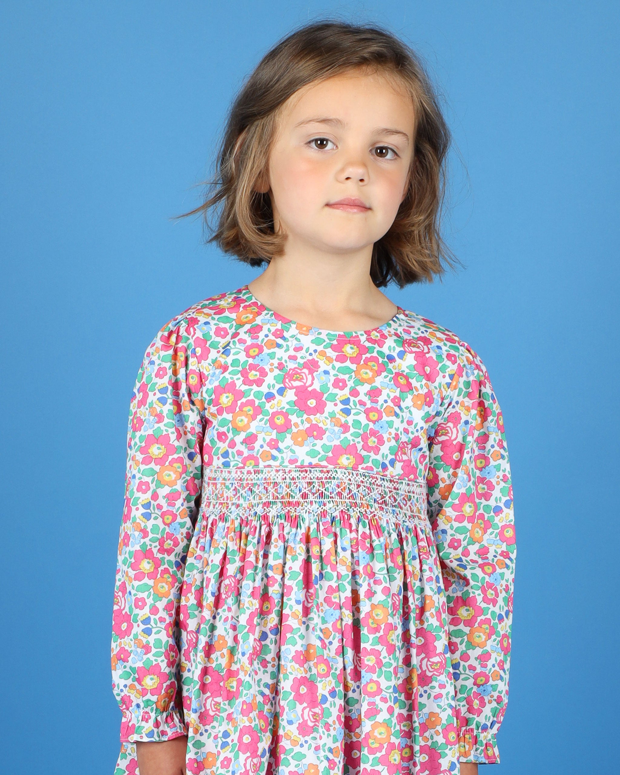 girl wearing hand-smocked liberty fabric dress