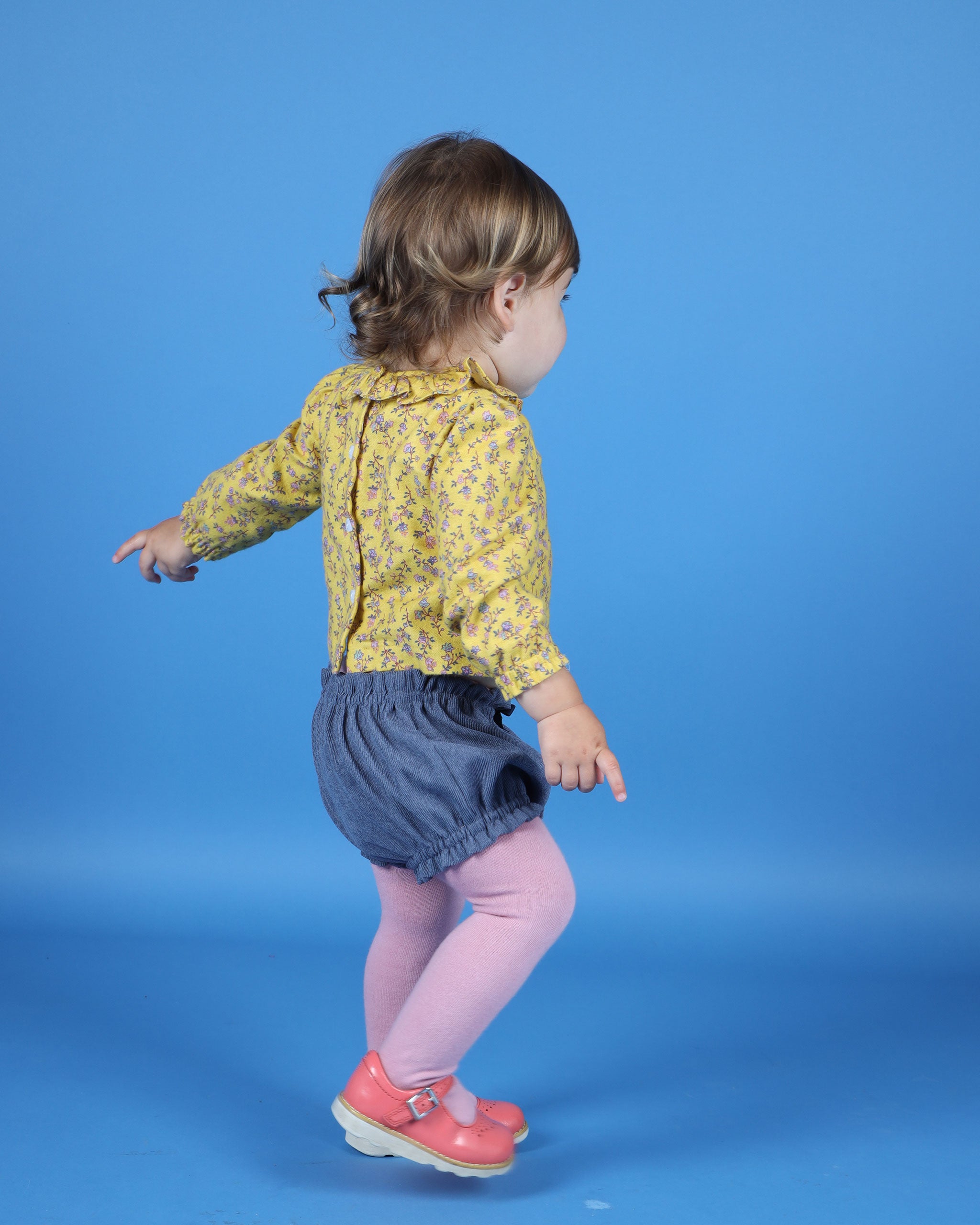 baby wearing grey shorts, back