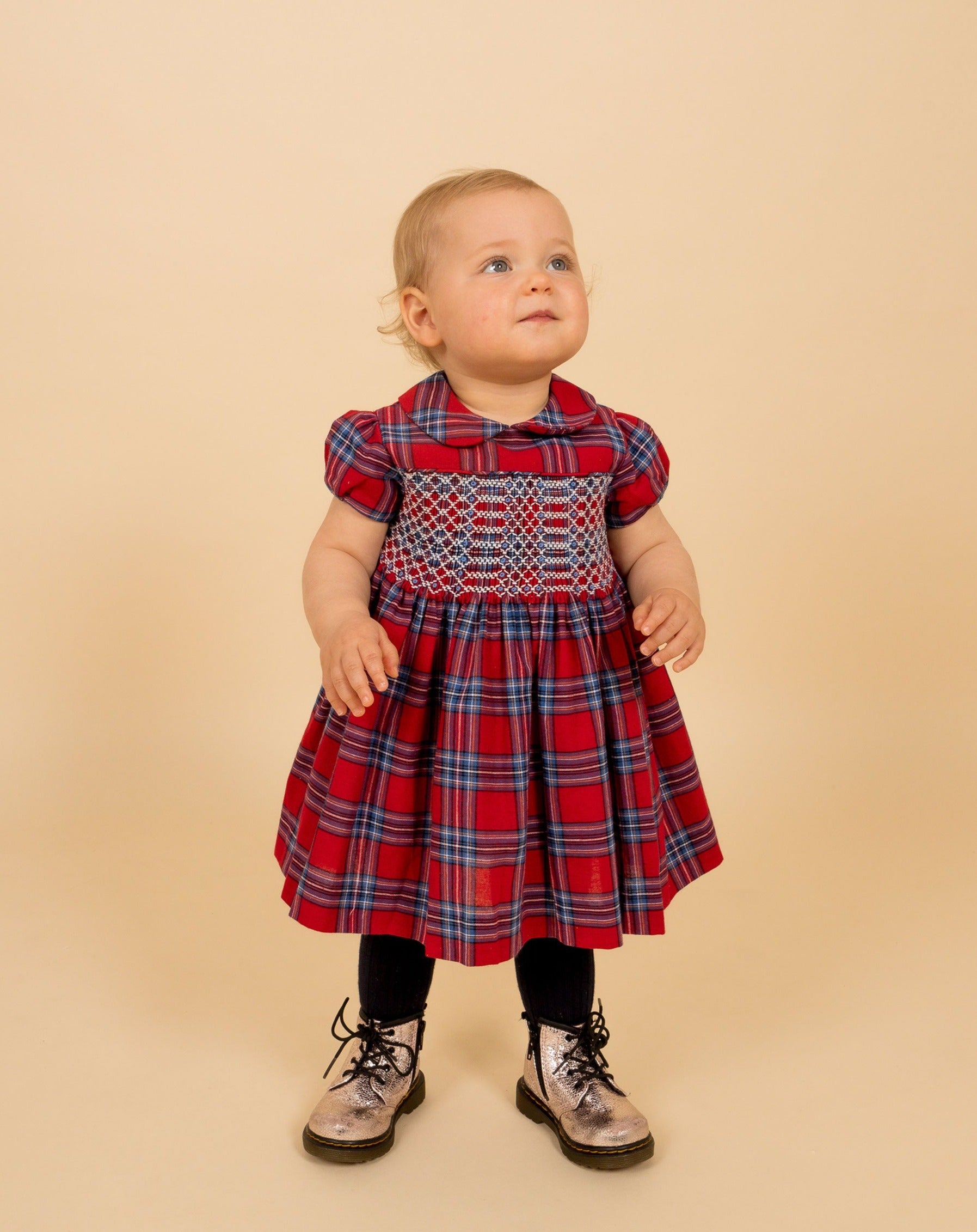 baby in red tartan smock dress