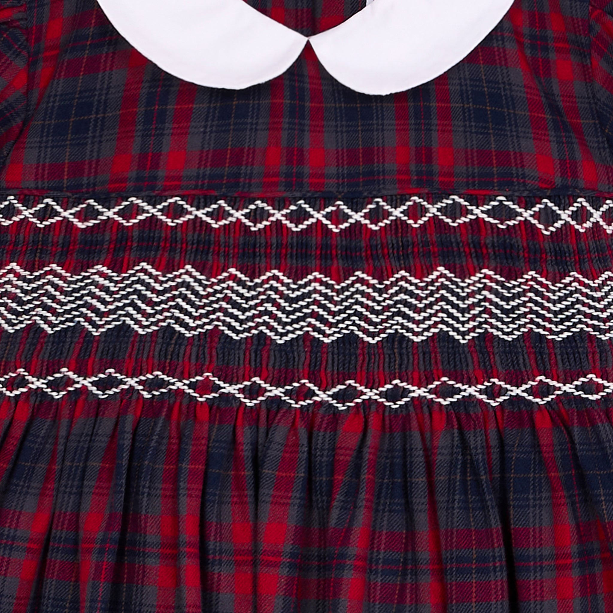 Red and blue plaid dress with white collar and intricate smcoking closeup