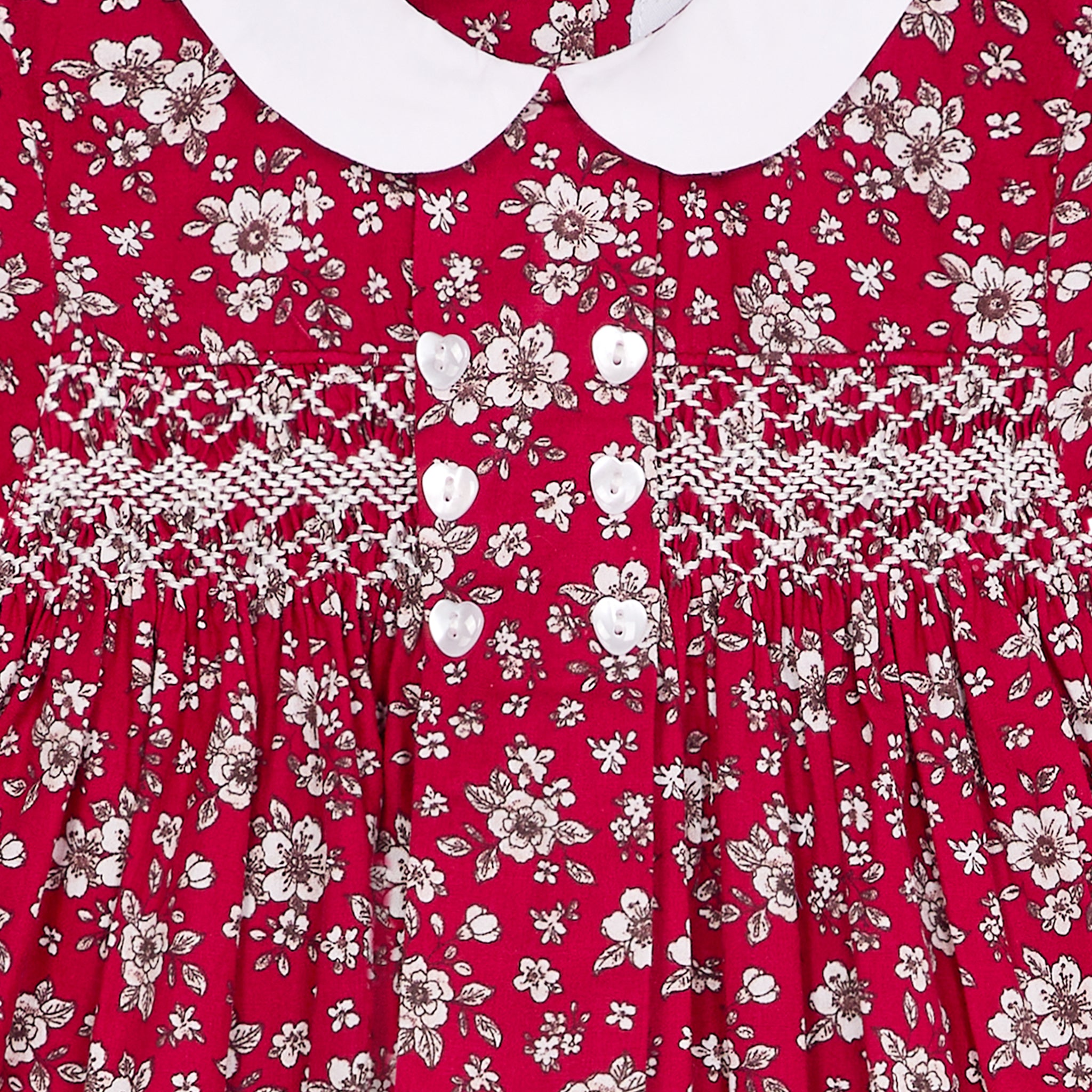Red floral dress with smocking closeup featuring heart shaped buttons