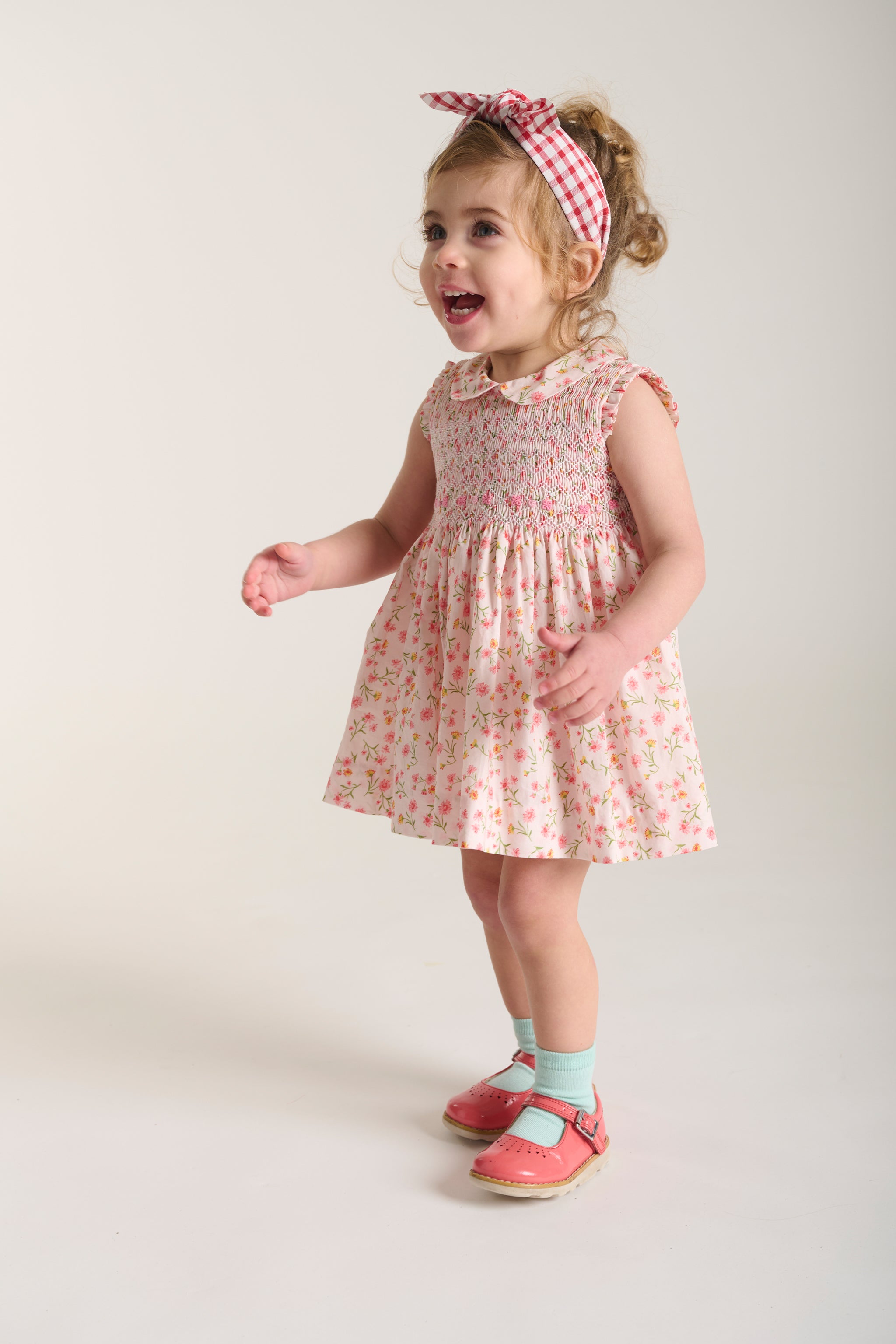 girl in pink smock dress laughing