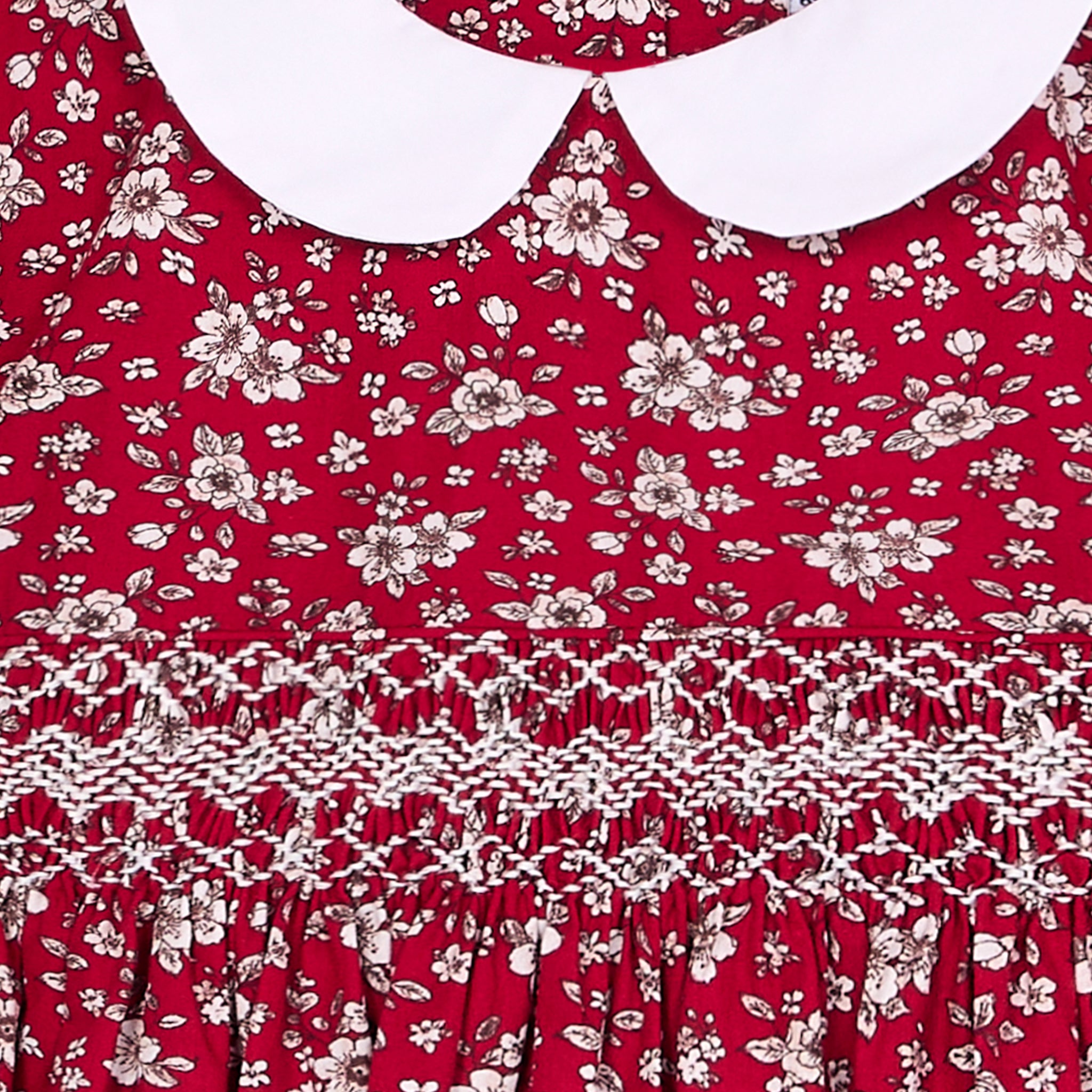 Red girls dress with white floral pattern and hand-smocking