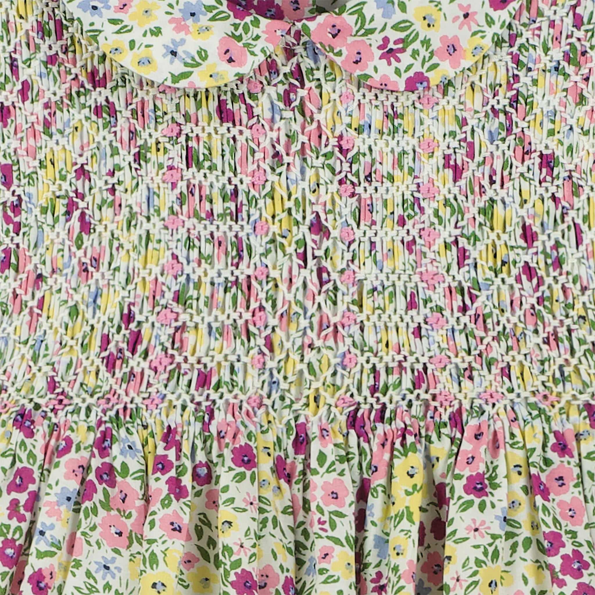 hand-smocked, floral baby dress, purple, pink and yellow blossoms, closeup of smocking