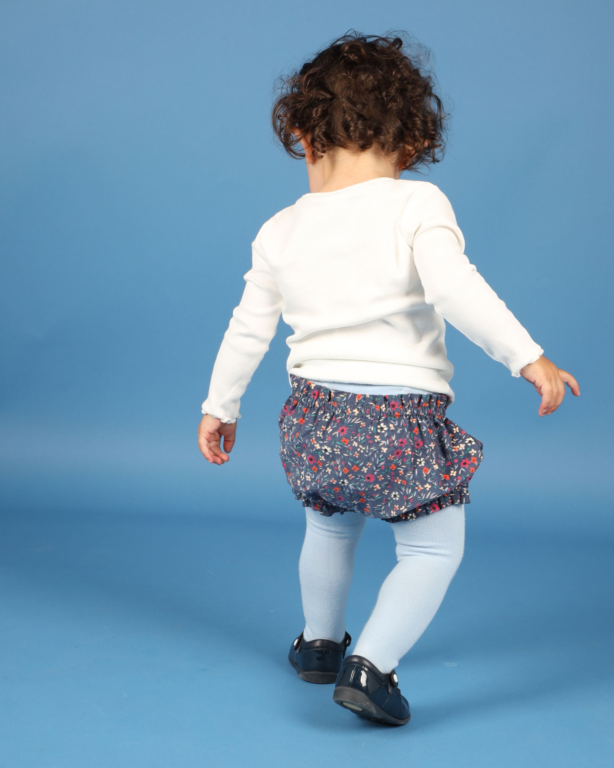 baby in floral shorts, back