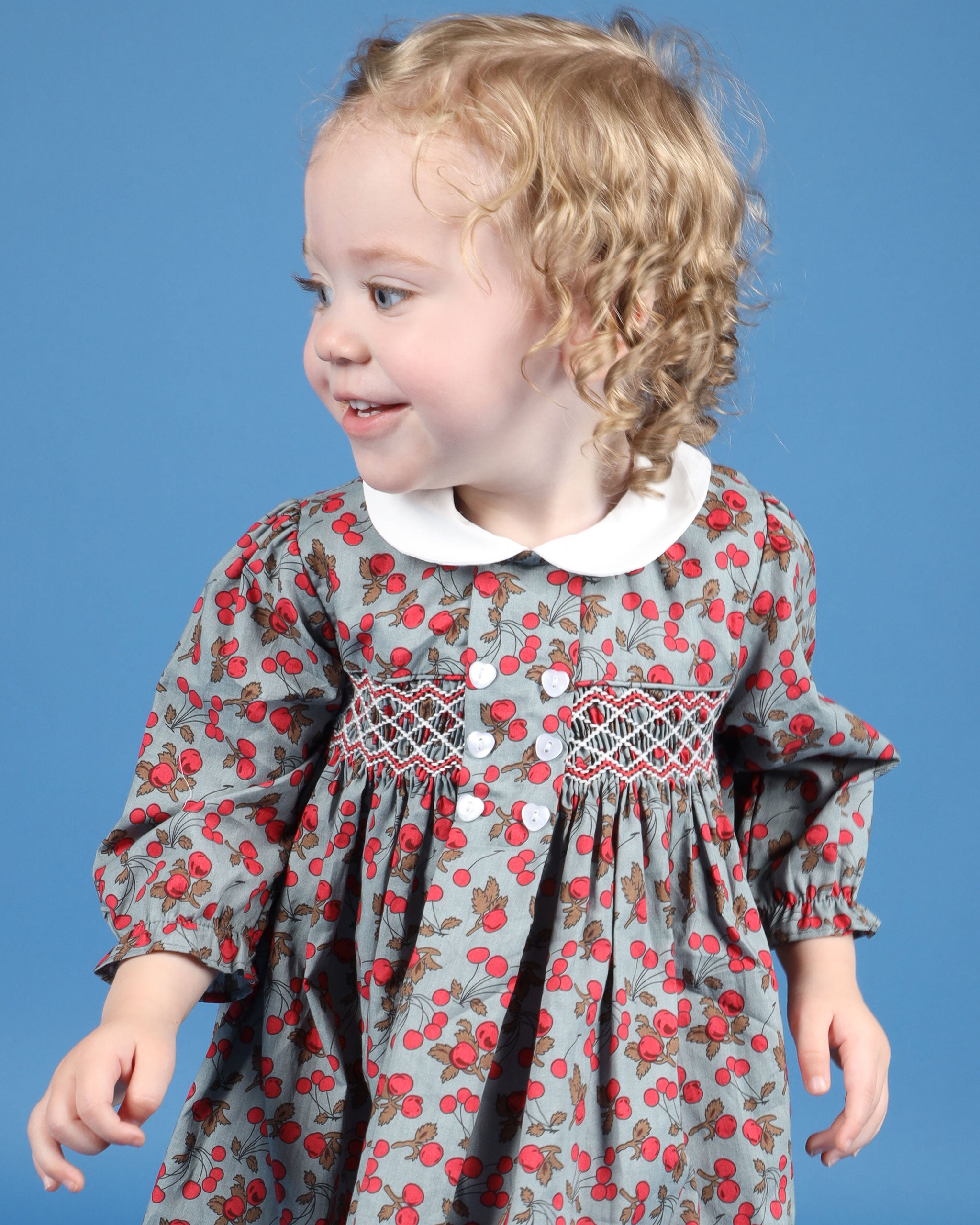 girl in cherry print smock dress