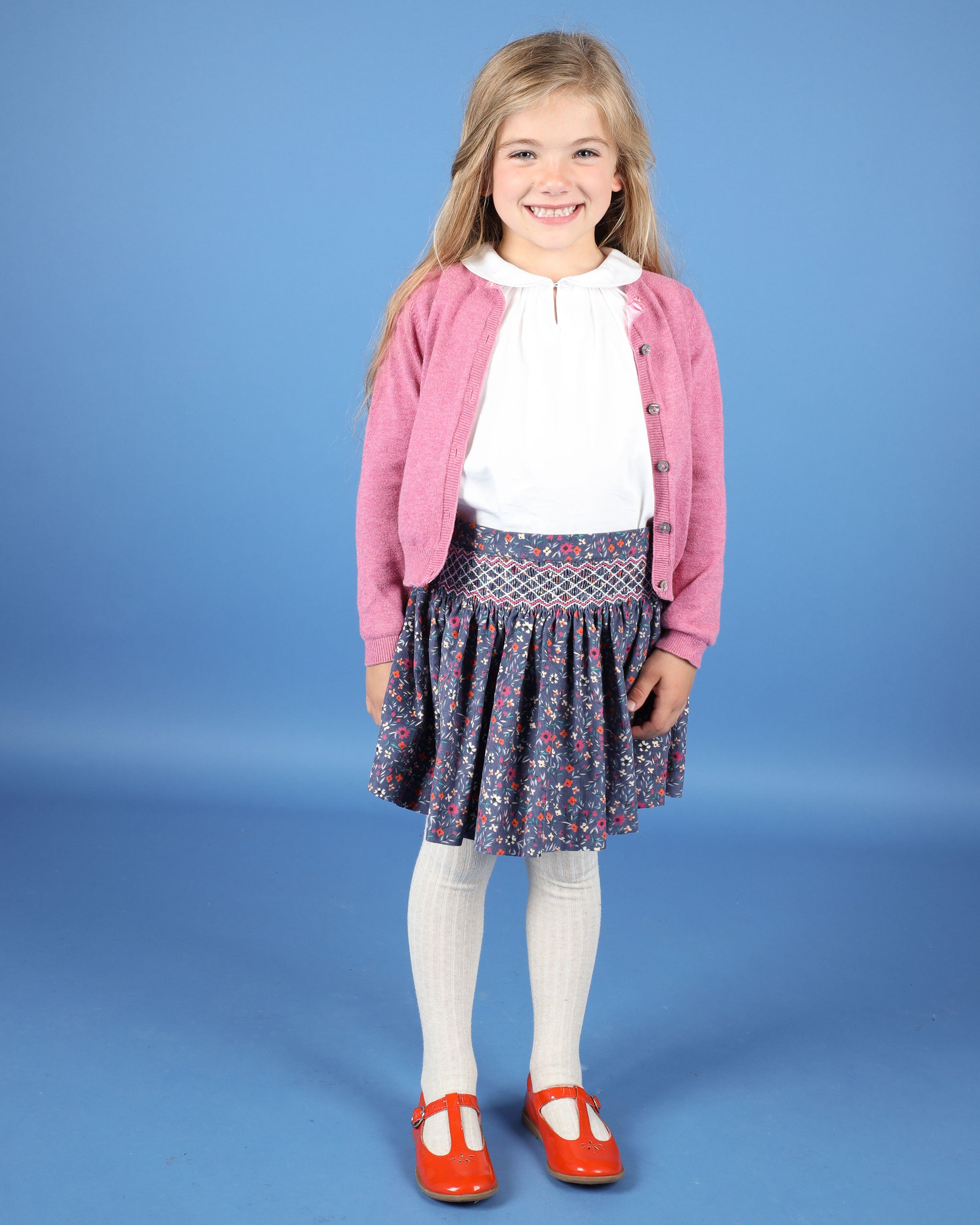 girl wearing hand-smocked corduroy skirt, navy, floral