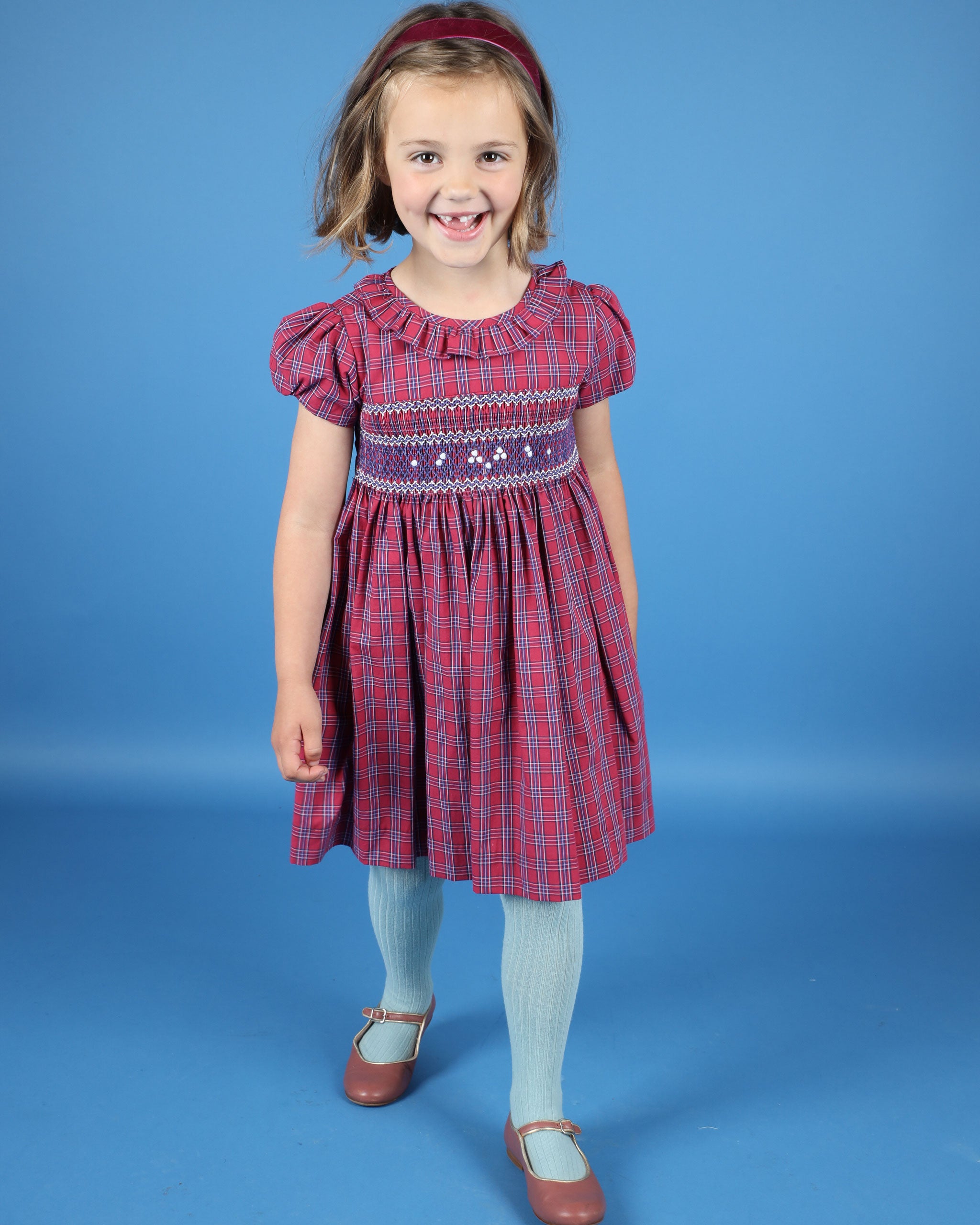 girl in smocked tartan dress with rill collar