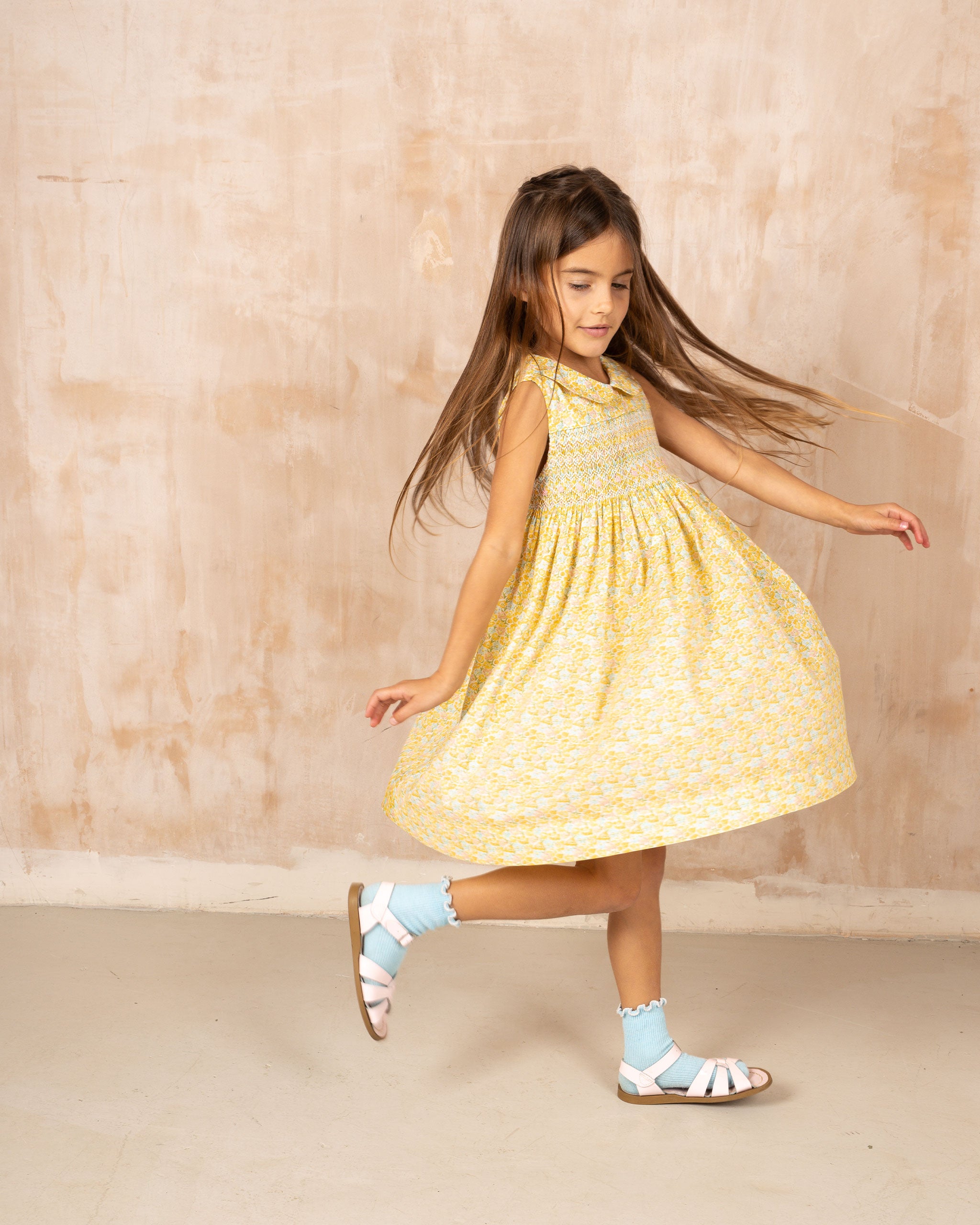 girl twirling in yellow smocked dress, spring fashion