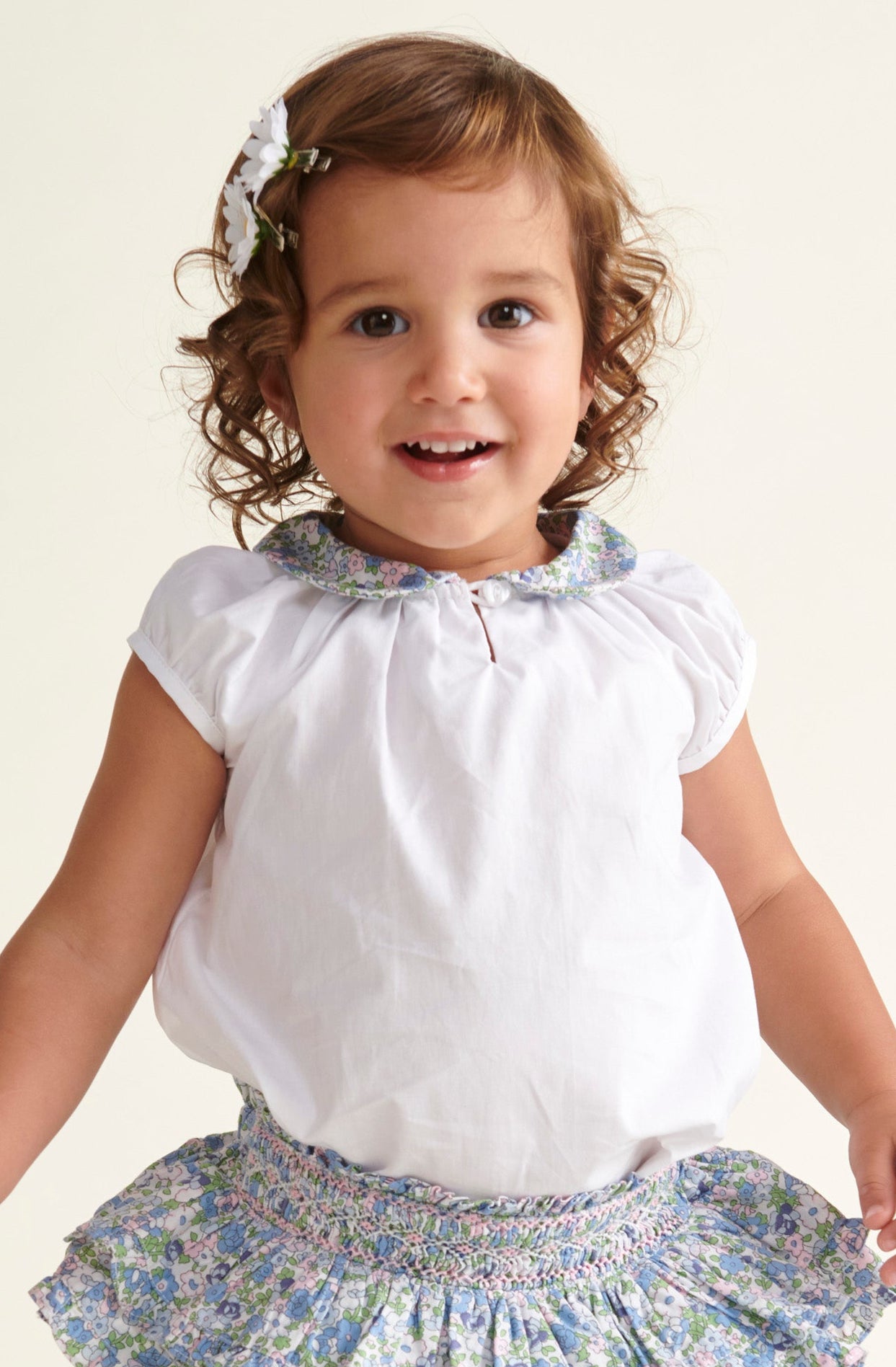 toddler in white blouse with floral collar