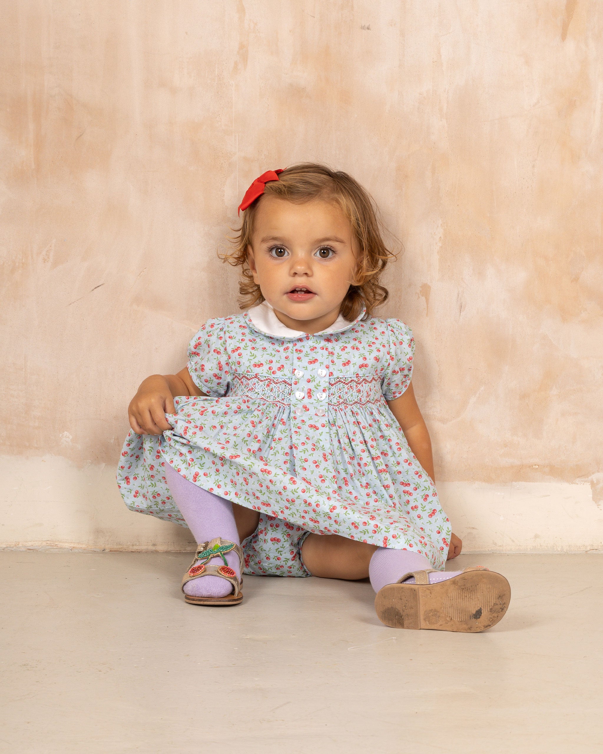 girl in smocked cherry dress with white collar