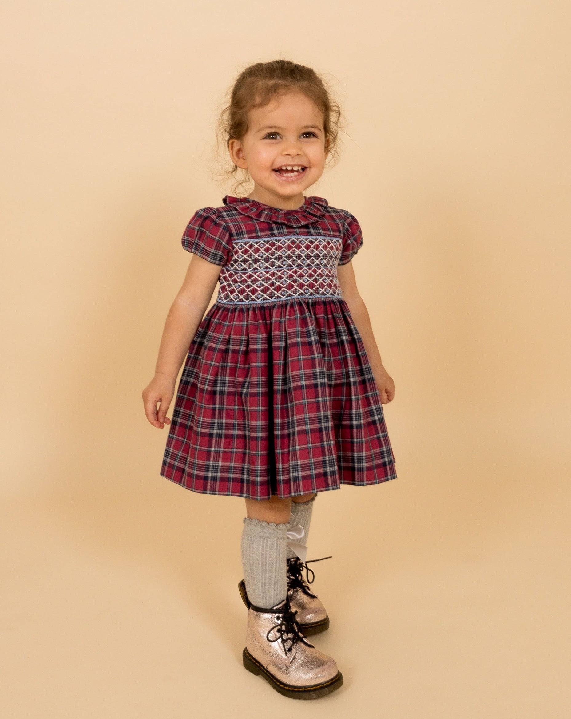 toddler model in burgundy tartan dress with smocking