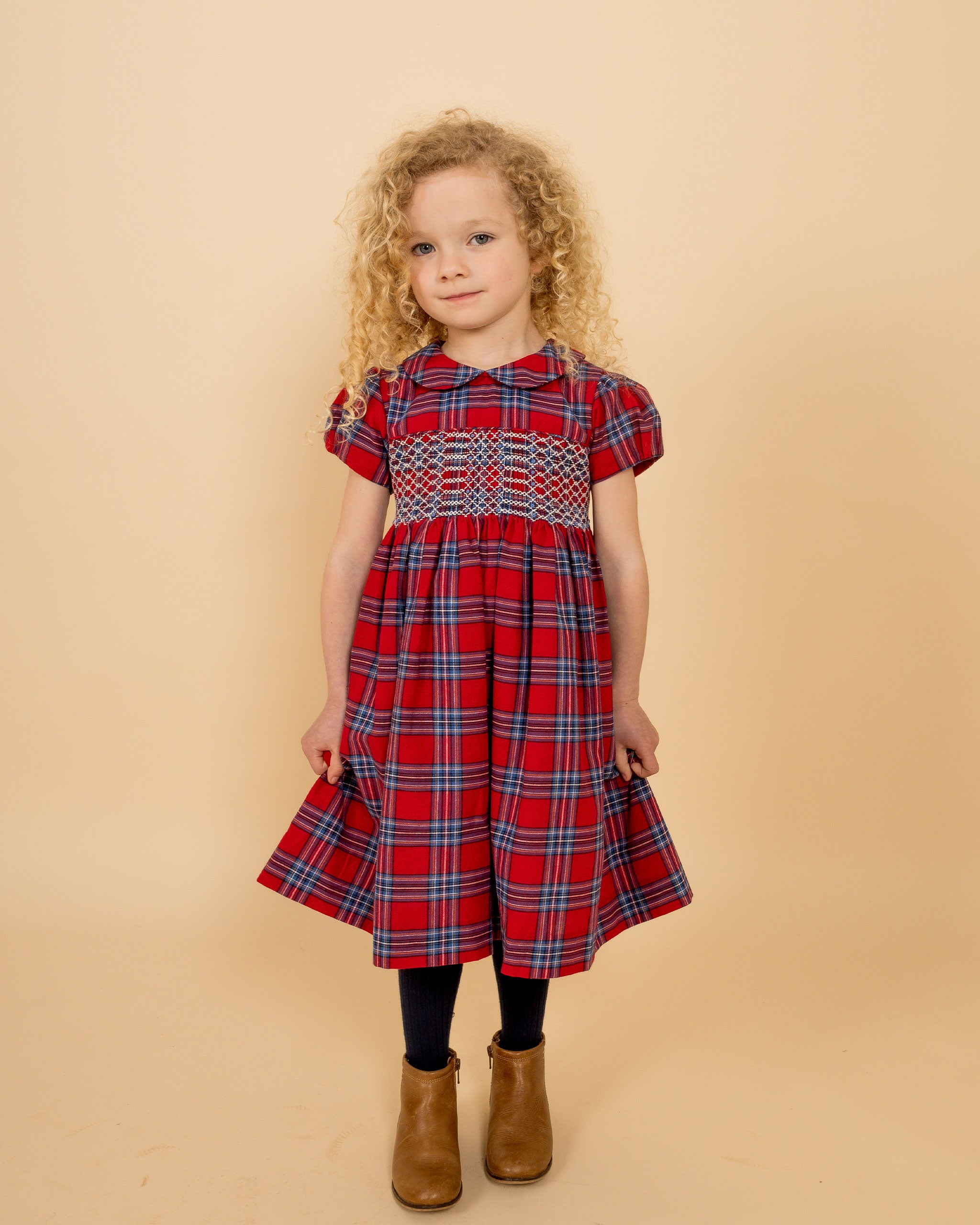 girl wearing a red tartan dress with smocking