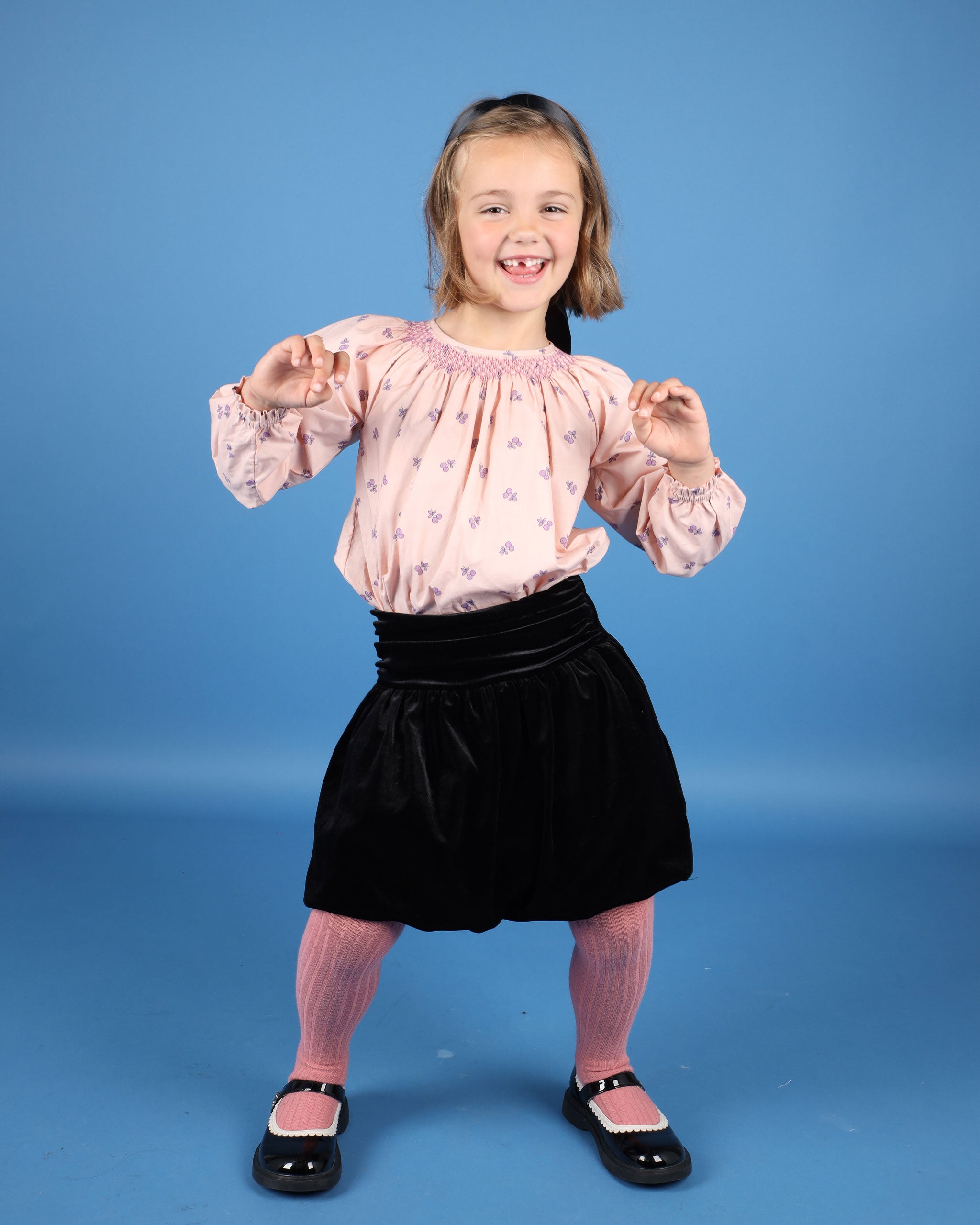 girl model in hand-smocked cherry print blouse