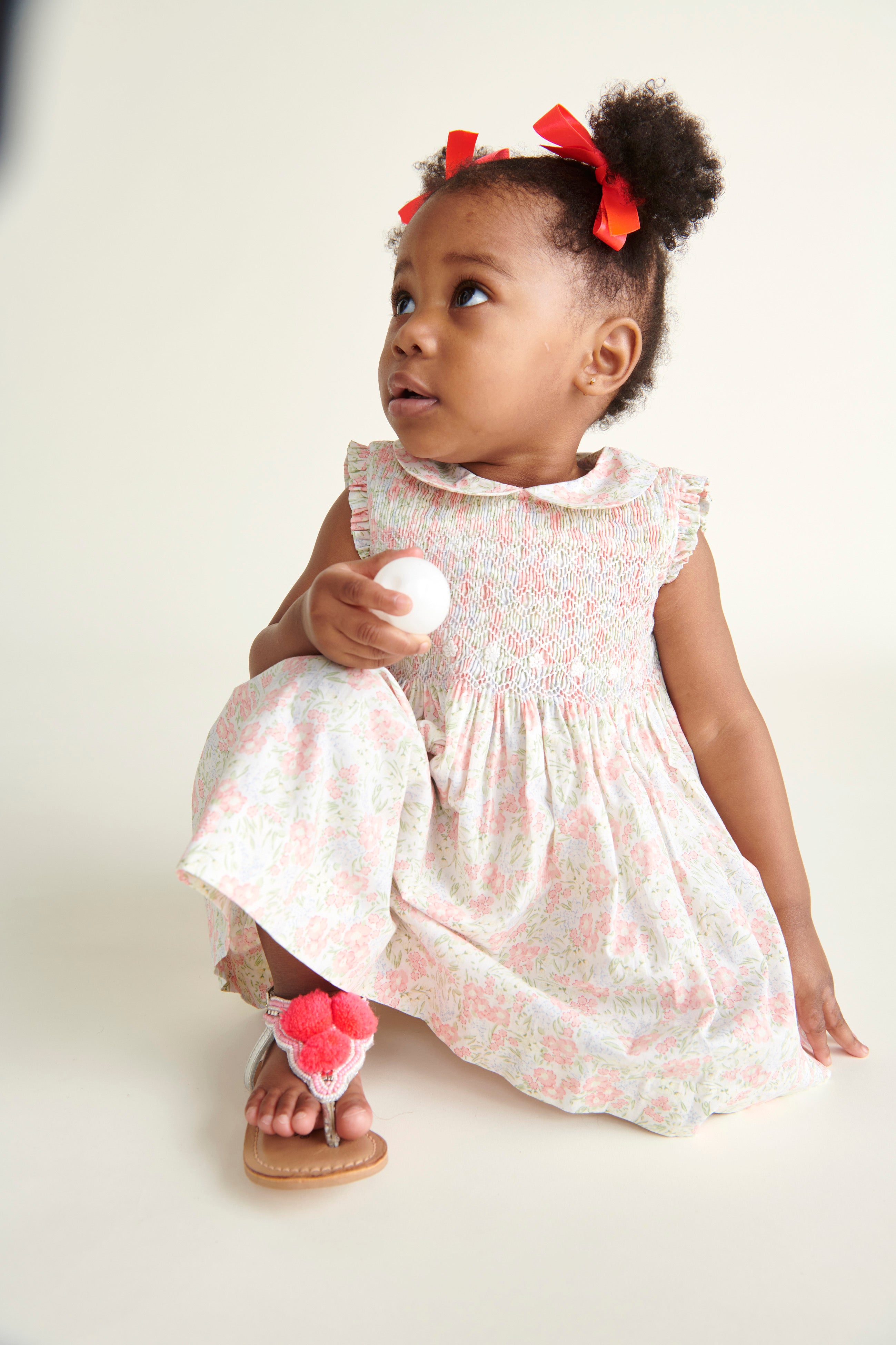 baby sitting on floor wearing hand-smocked dress