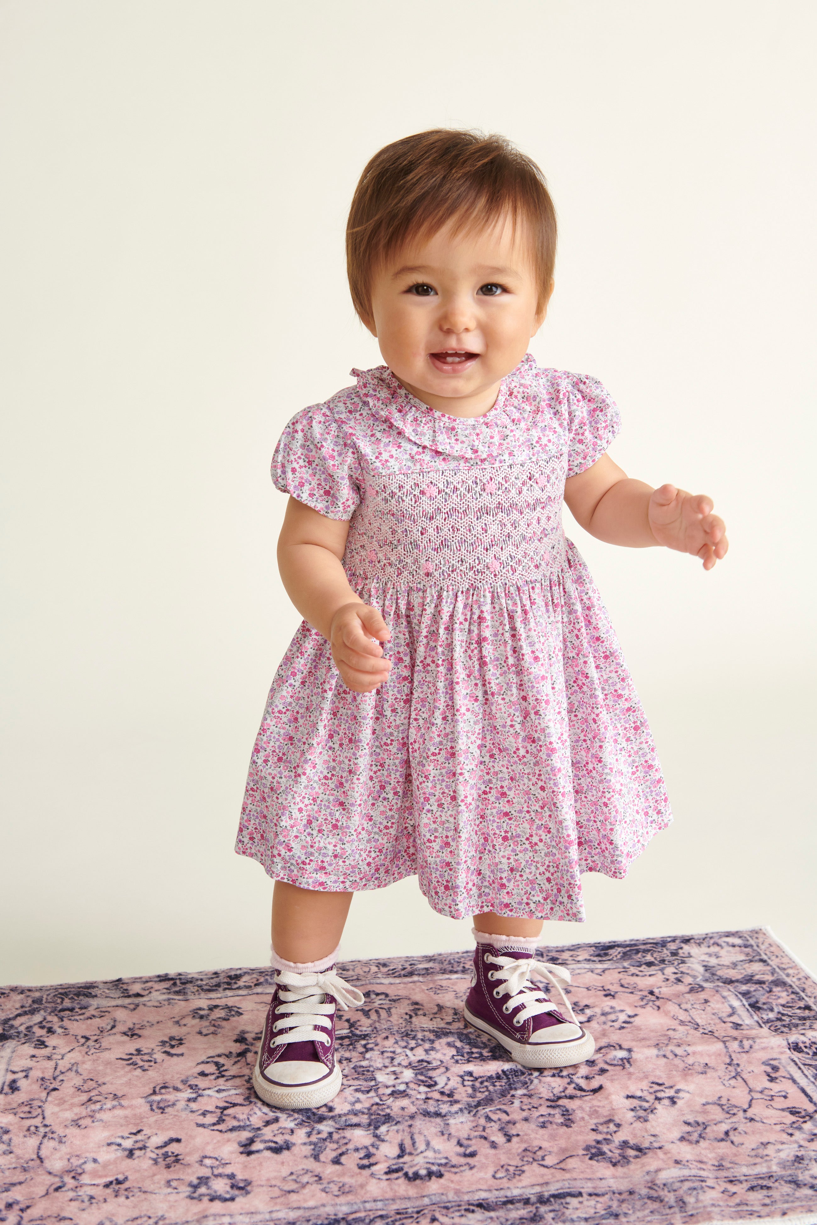 baby in pink dress, standing