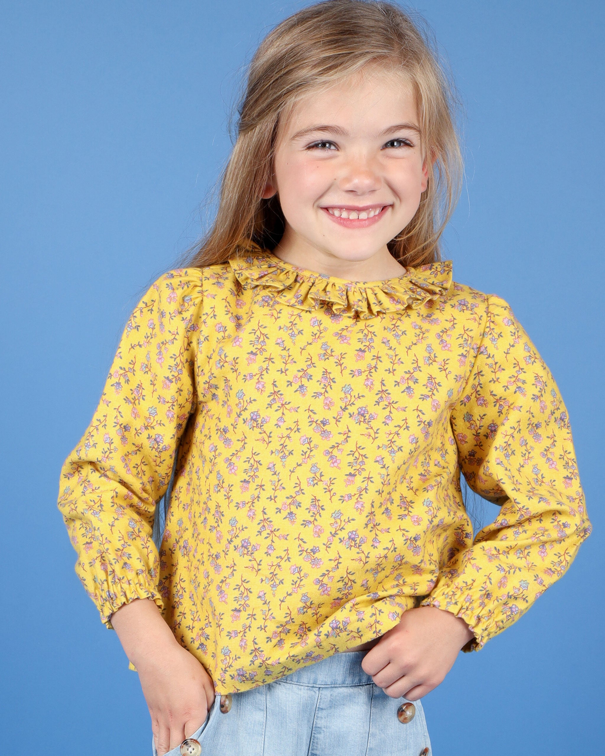 girl in floral yellow blouse with frill collar