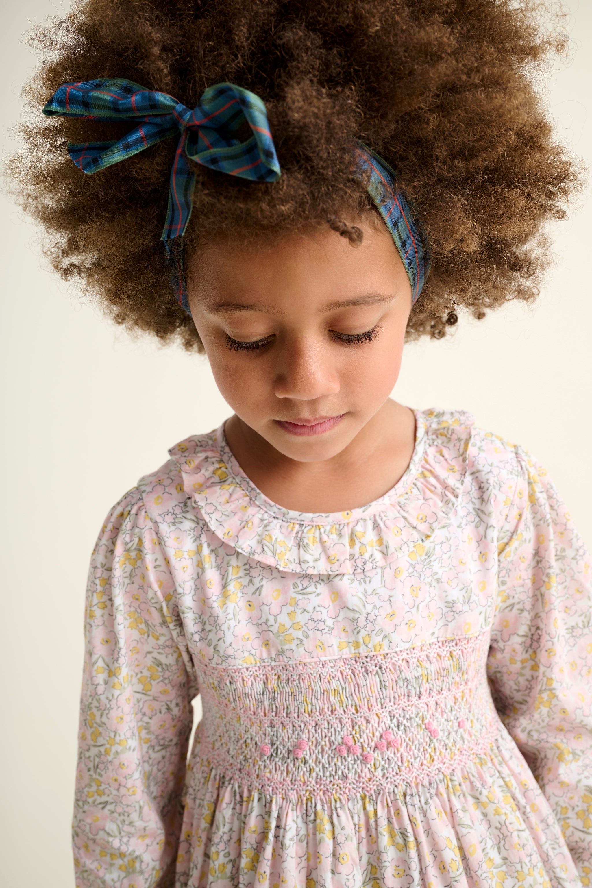 Young girl wearing a floral smock dress closeup