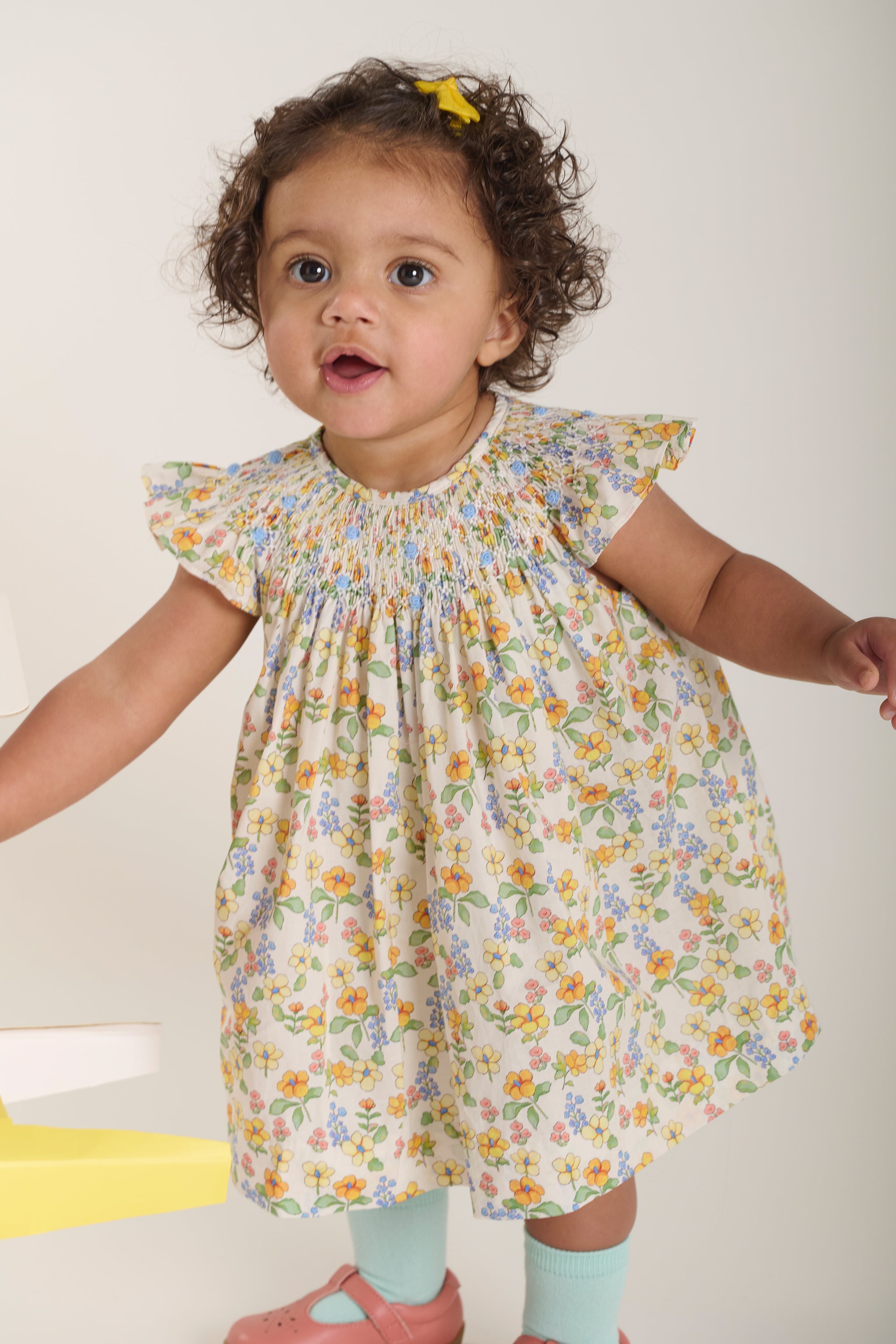 toddler girl in yellow floral hand-smocked dress