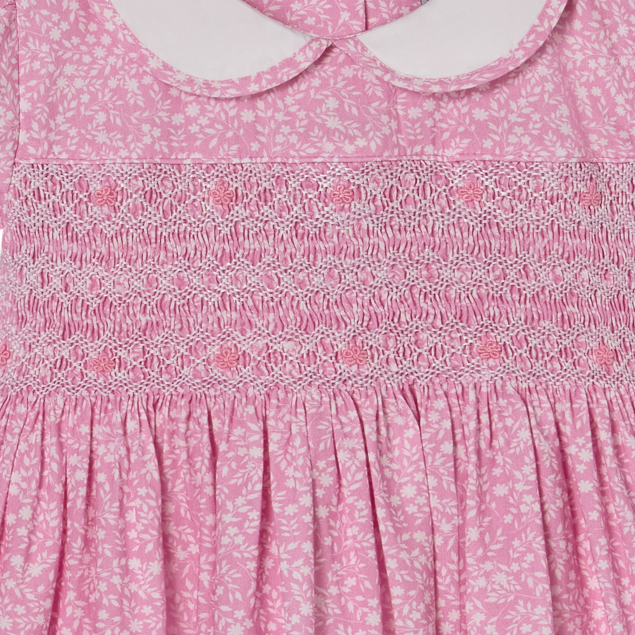 Close-up of a pink floral dress with smocked details
