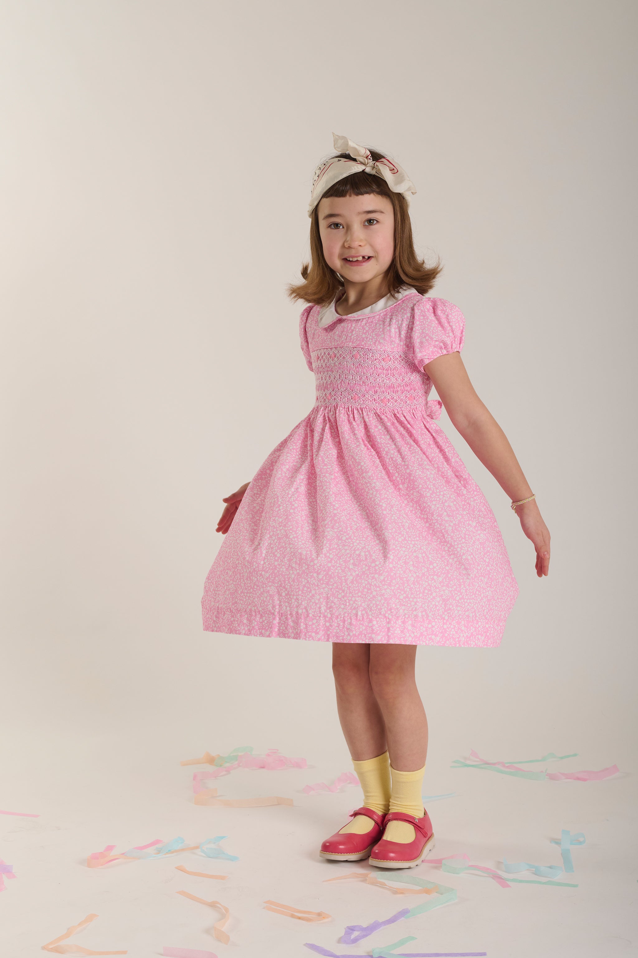 Young girl wearing a pink dress and twirling
