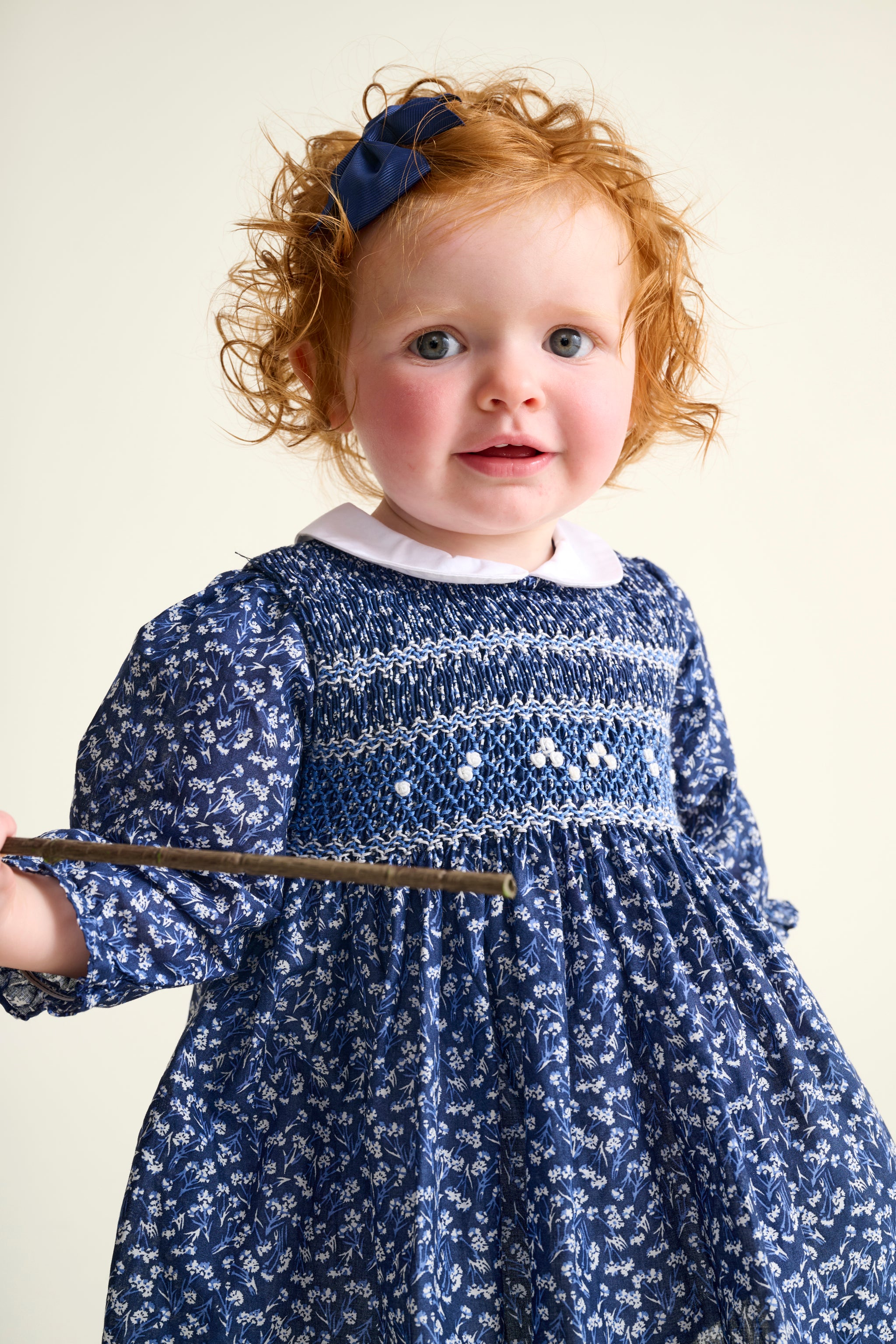 Toddler girl wearing a blue floral dress with a white collar