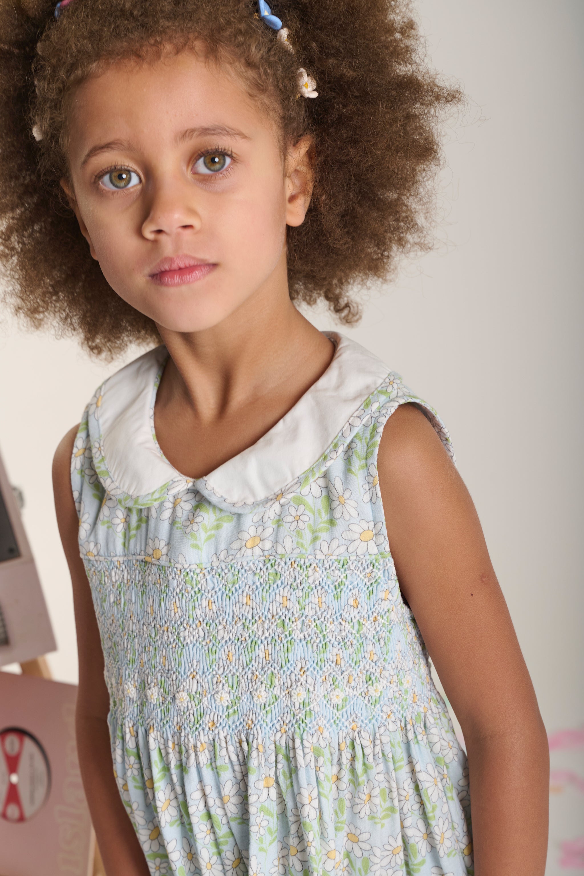 Young girl wearing a floral dress with daisy print close up