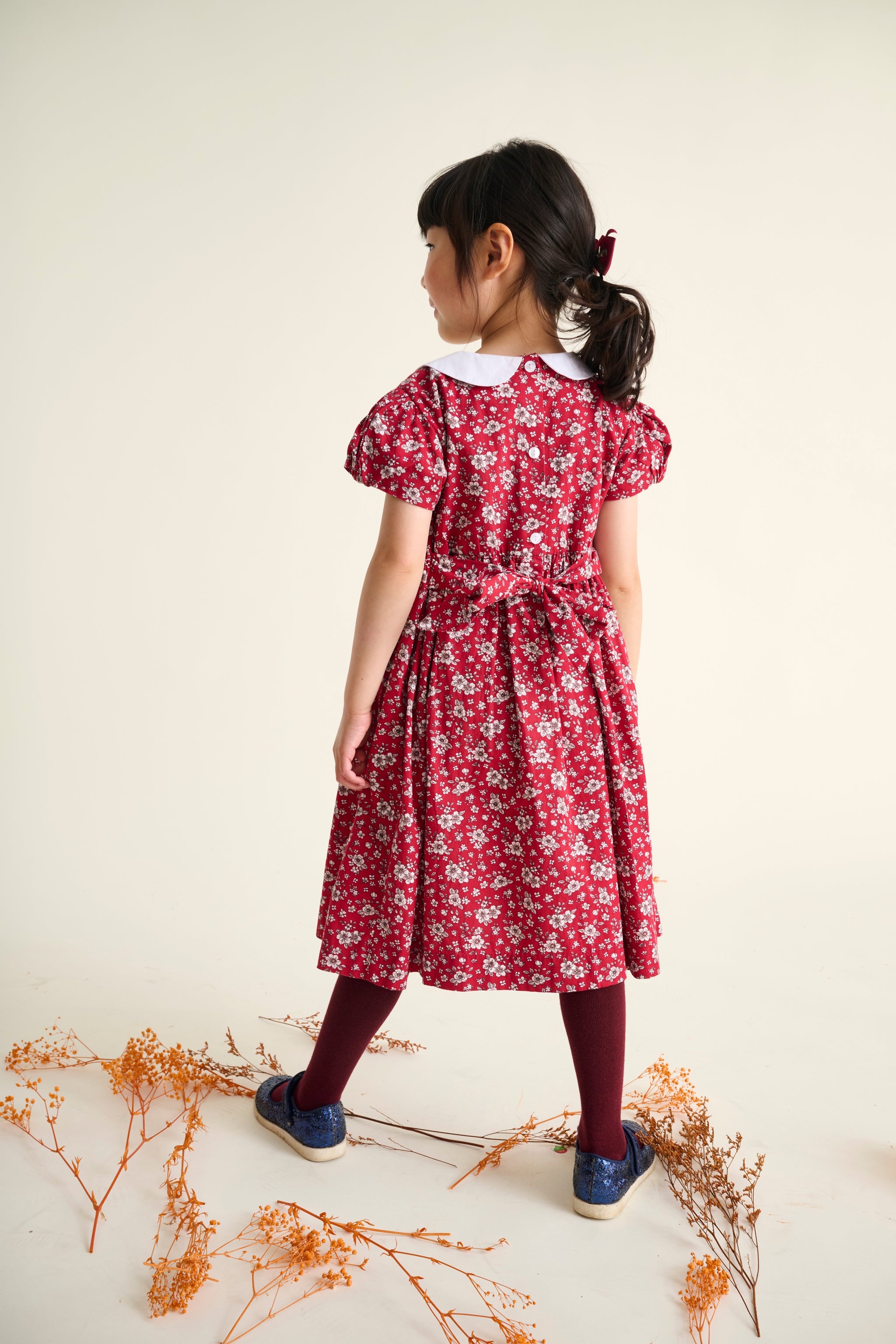 child wearing a red floral dress back view