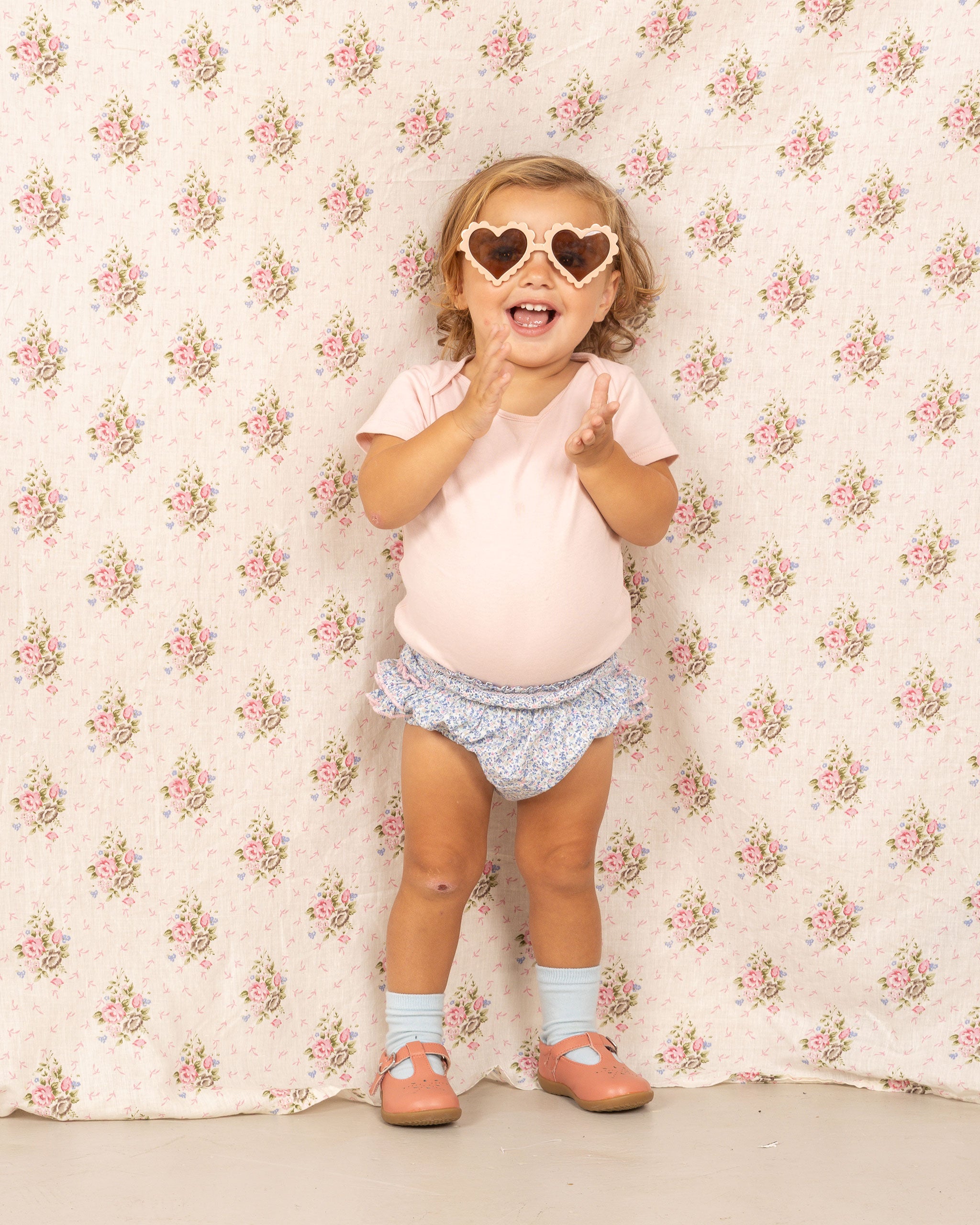 happy baby in blue floral bloomers