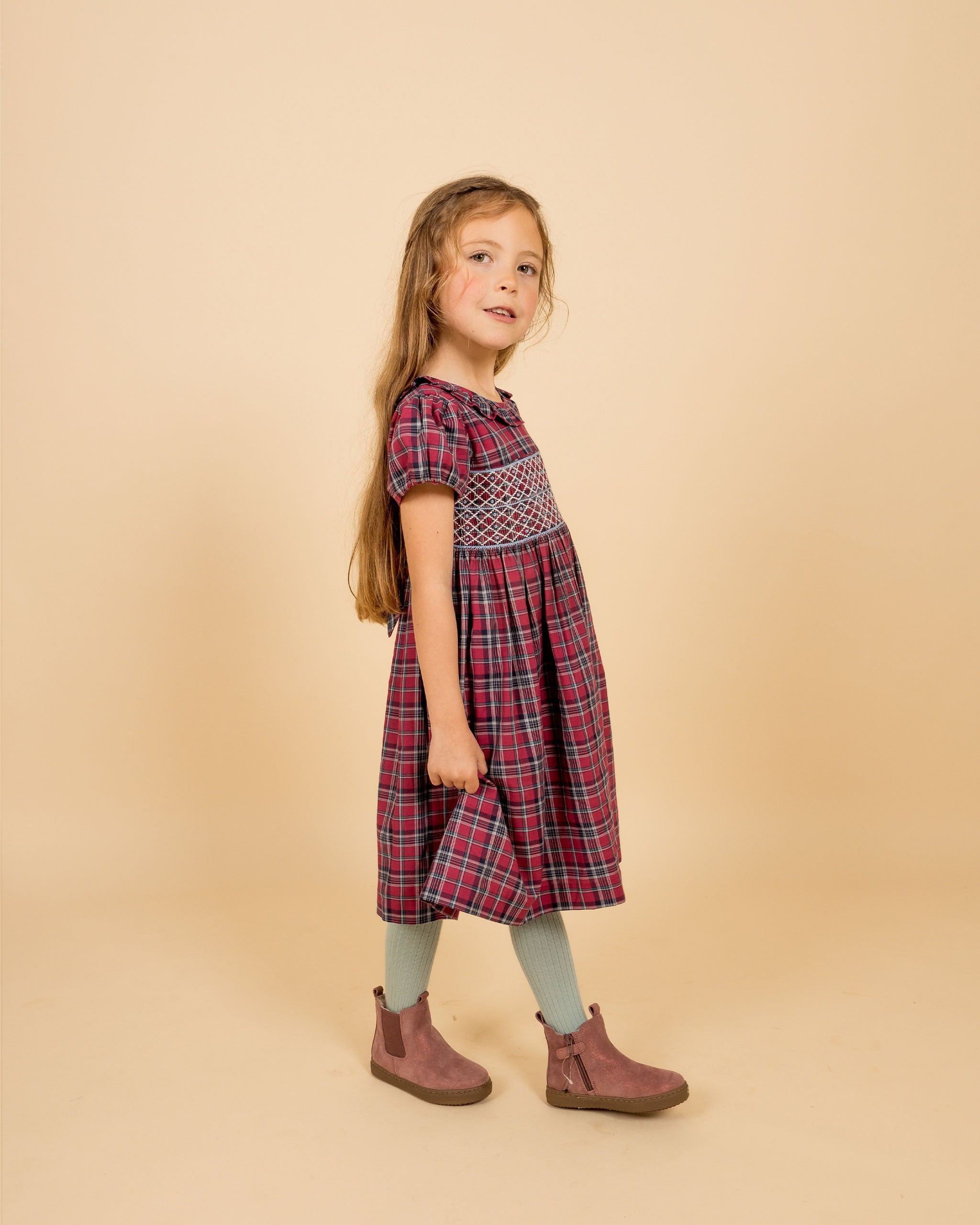 girl wearing tartan smock dress, burgundy