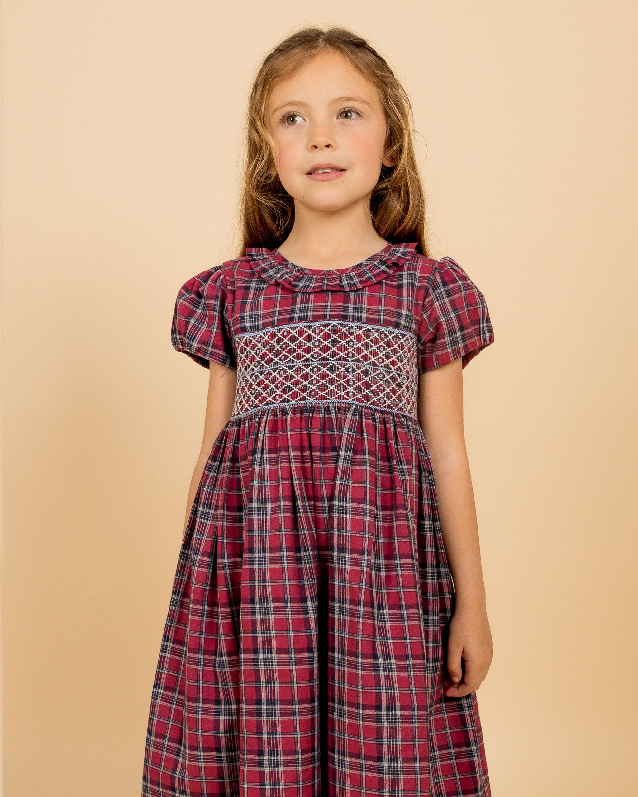 girl in festive tartan dress with smocking