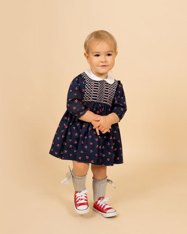 toddler in navy cherry print dress with hand-smocking