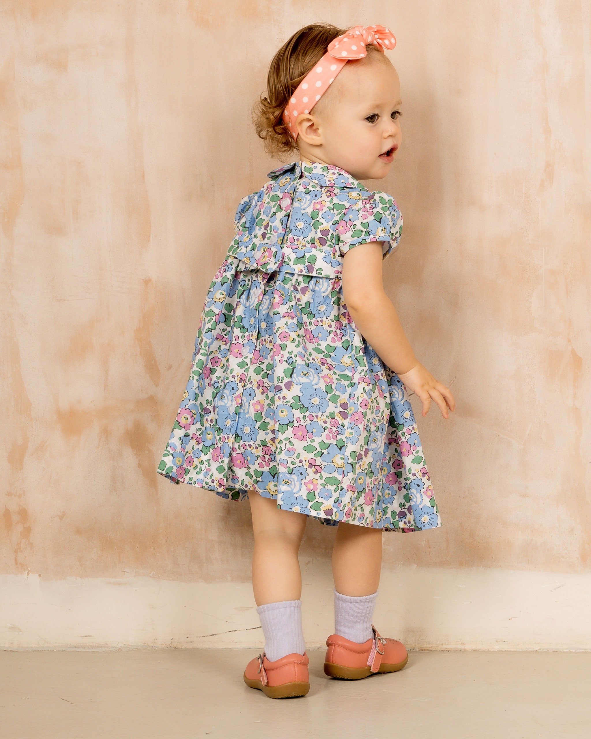 baby model in hand-smocked dress, back view 