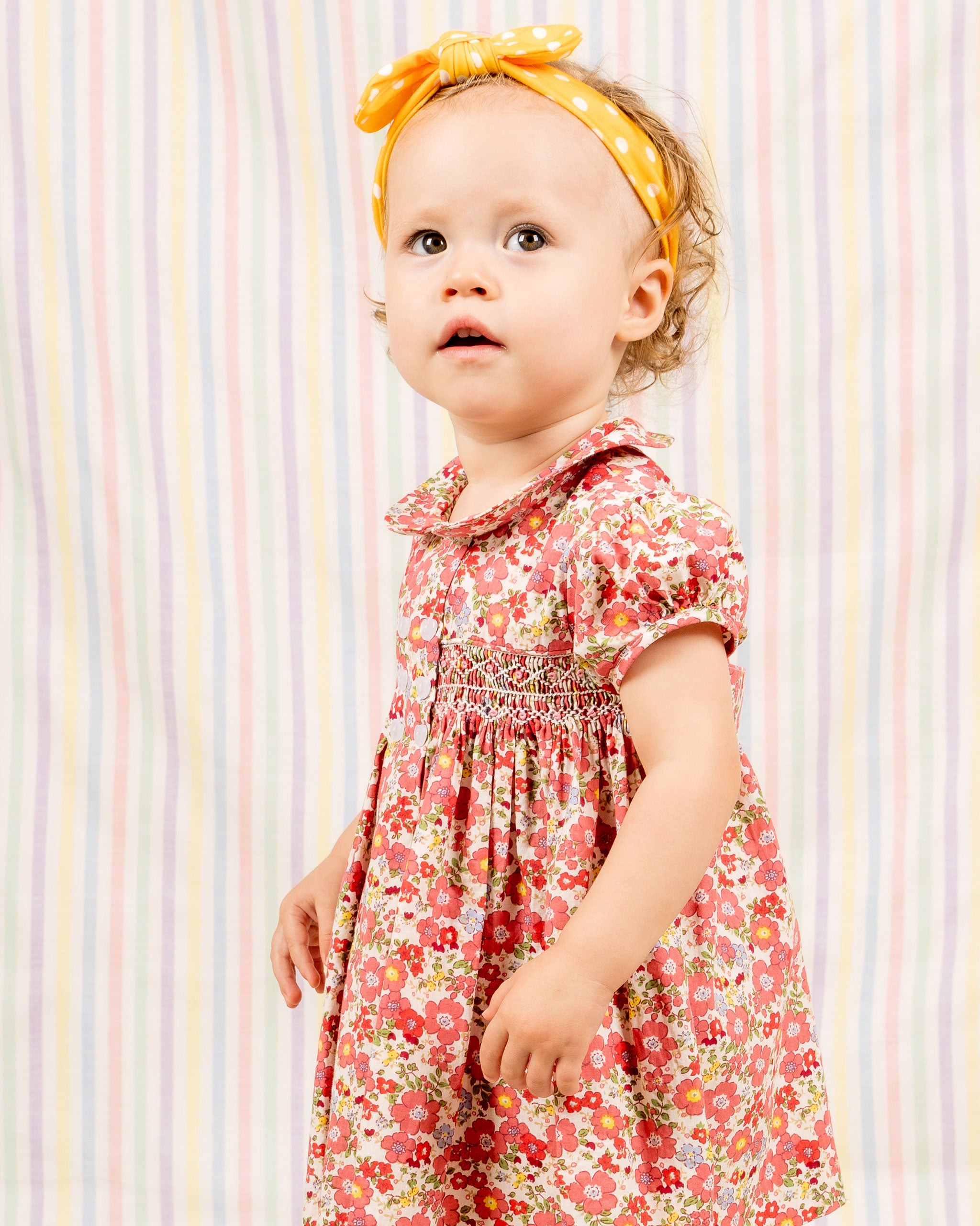 toddler in red floral smock baby dress