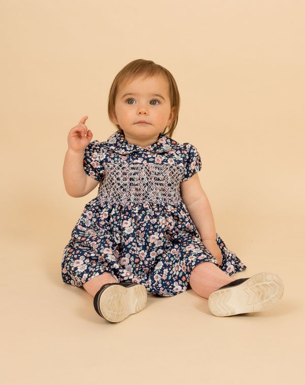 baby in hand-smocked, floral winter dress