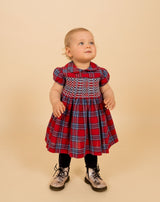 baby in red tartan smock dress