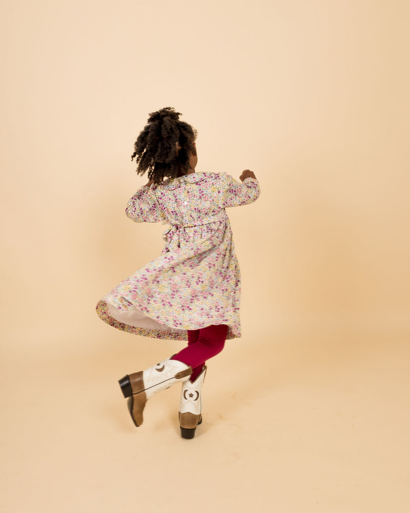 child spinning in hand-smocked dress