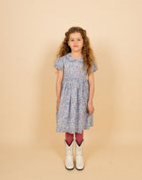 girl in blue Liberty print fabric dress, wearing cowboy boots