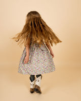 girl in made with Liberty print dress, twirling