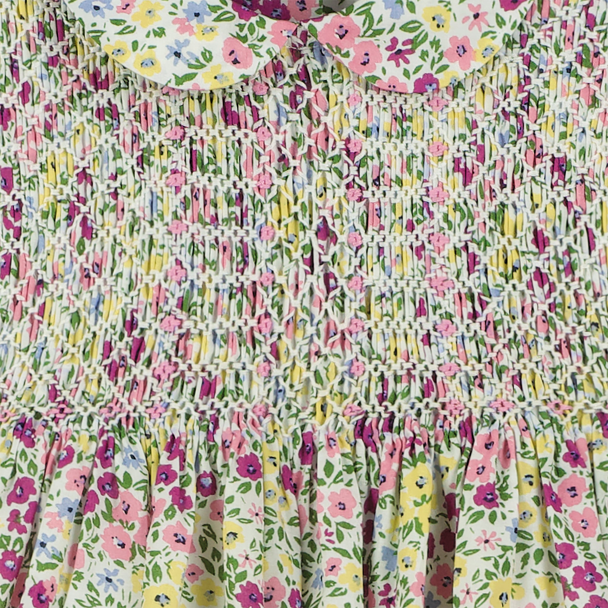 hand-smocked, floral baby dress, purple, pink and yellow blossoms, closeup of smocking