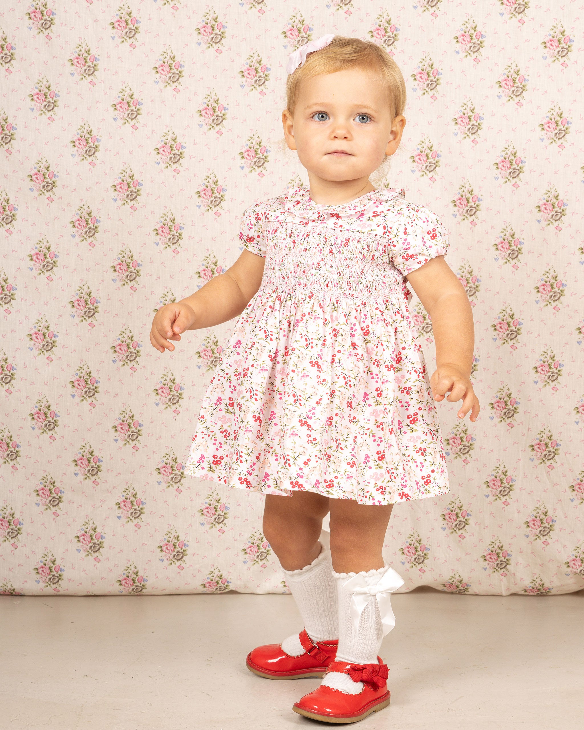 cute toddler girl in hand-smocked, floral dress