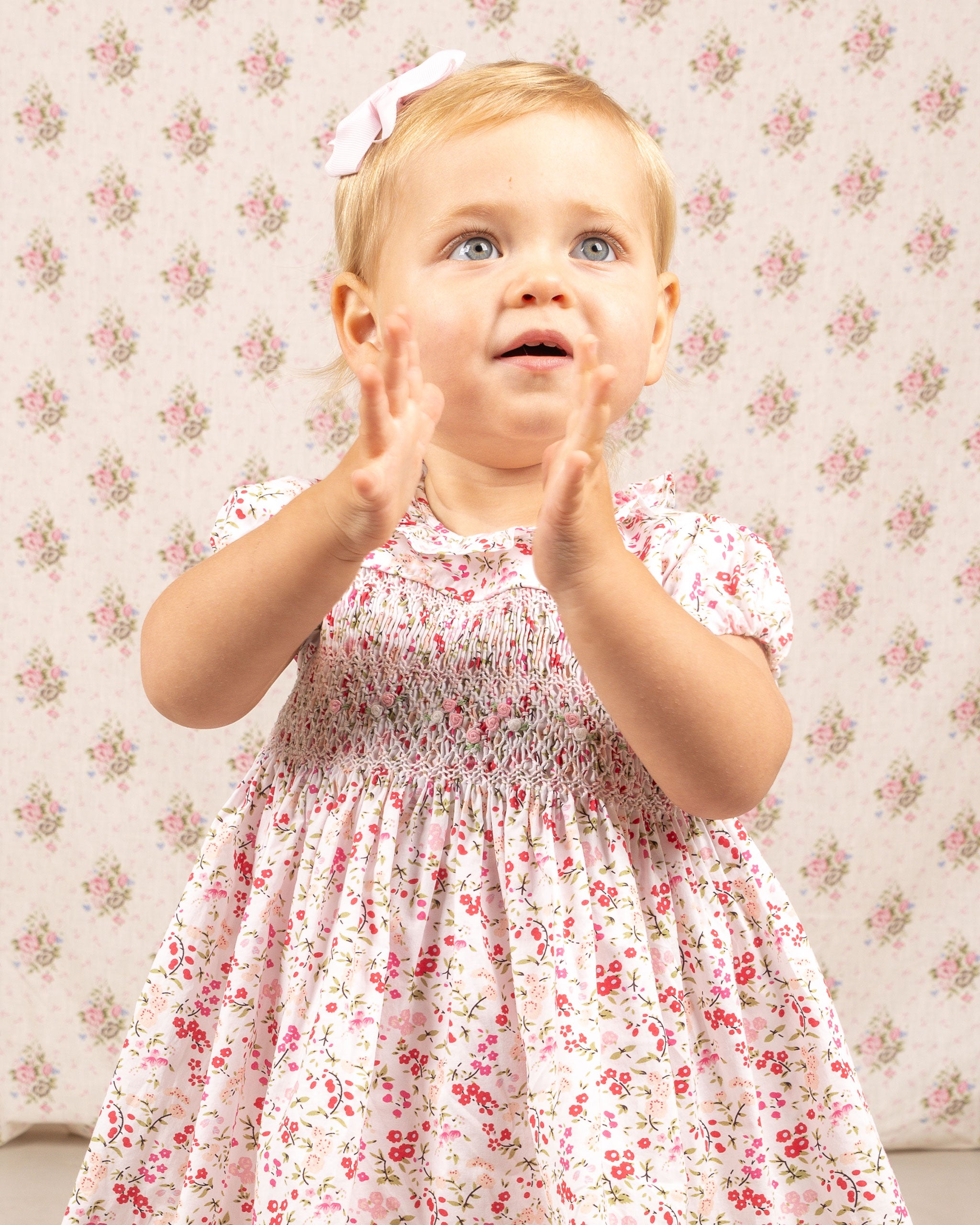 girl in smock dress, floral, red and pink on white