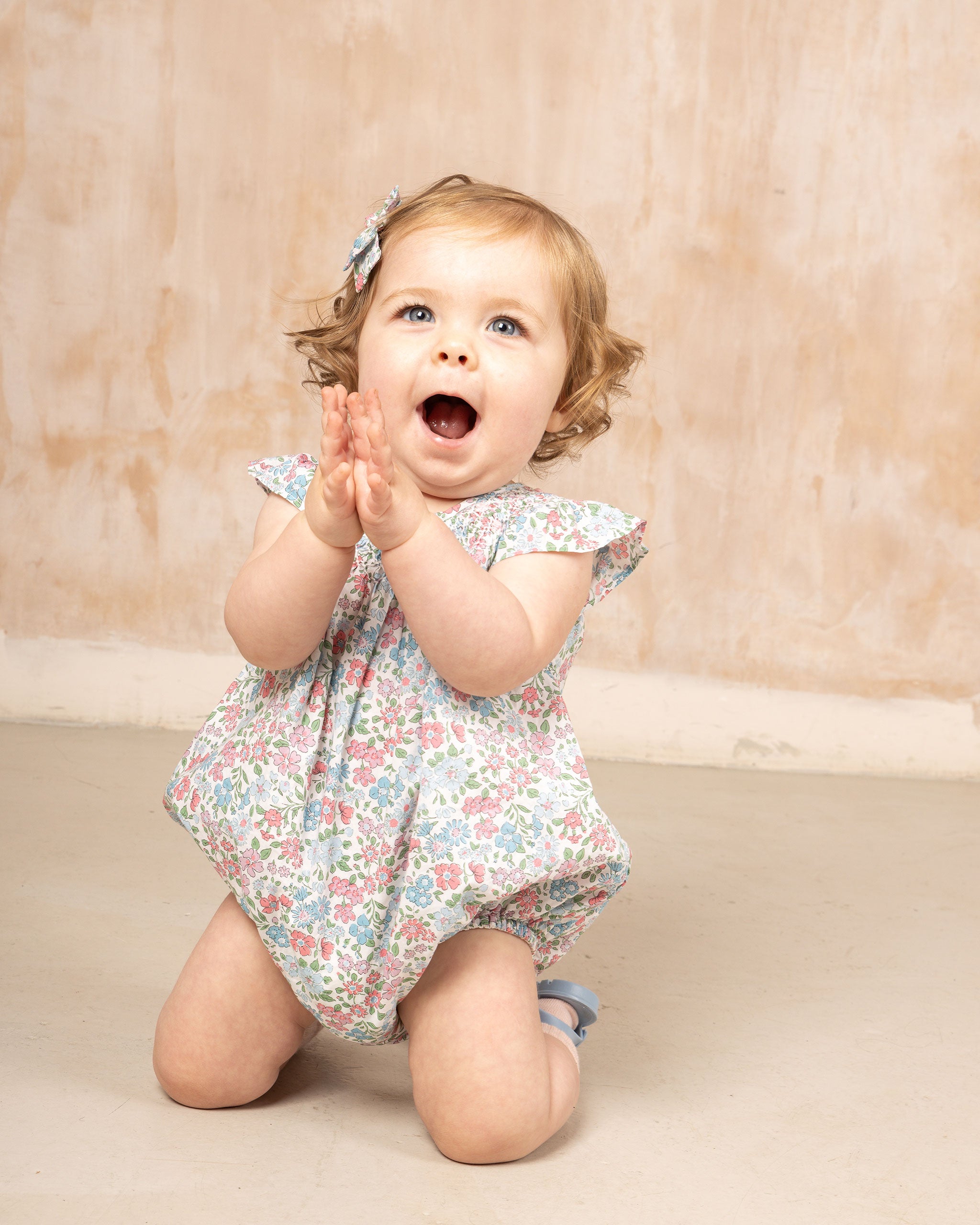 happy baby in floral outfit